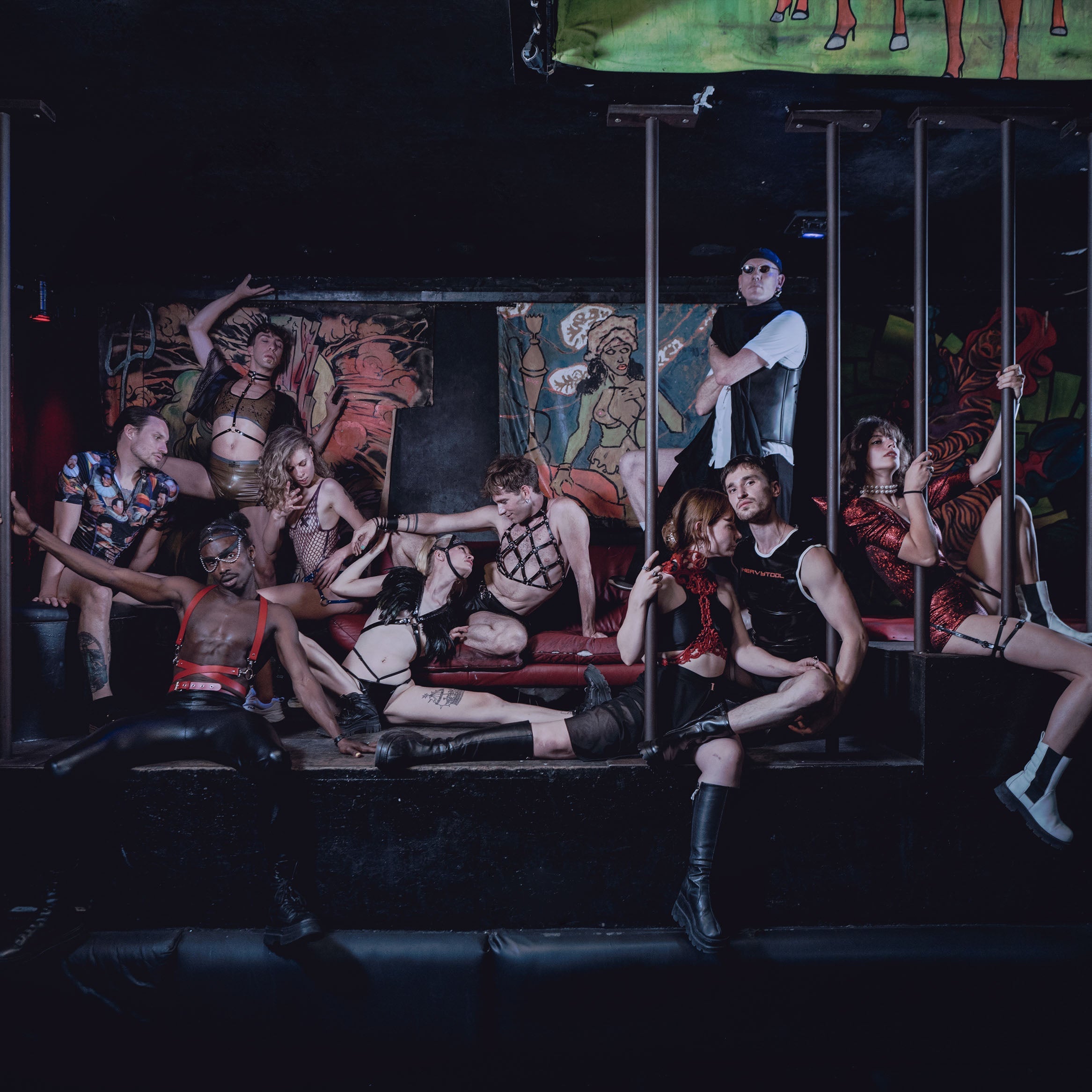 Group of kinky people in kit kat club with nice clubbing outfits laying around.