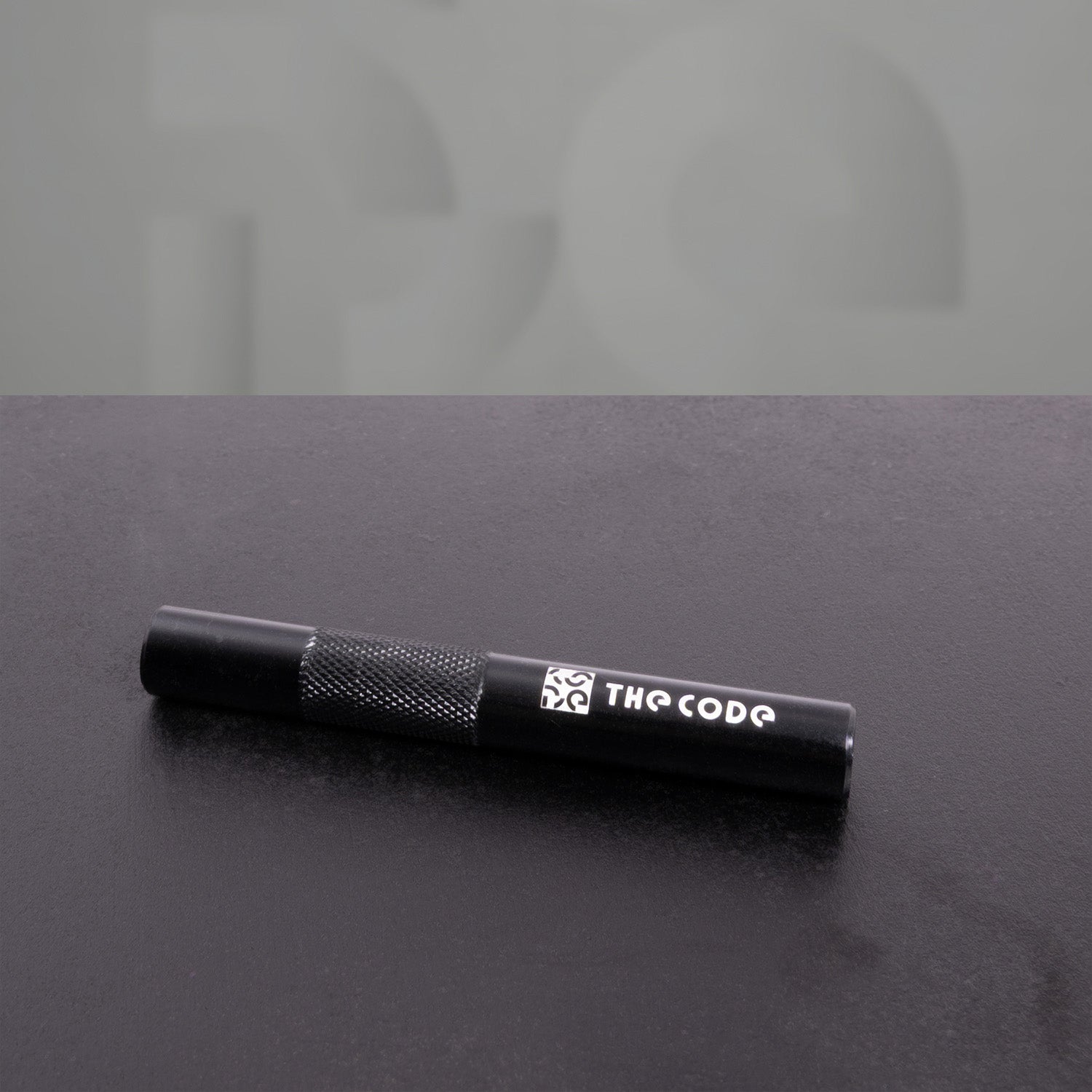 This image showcases a sleek black straw from "The Code." Its modern design and textured grip make it both stylish and functional, perfect for sipping in style. Elevate your beverage experience with this chic accessory!