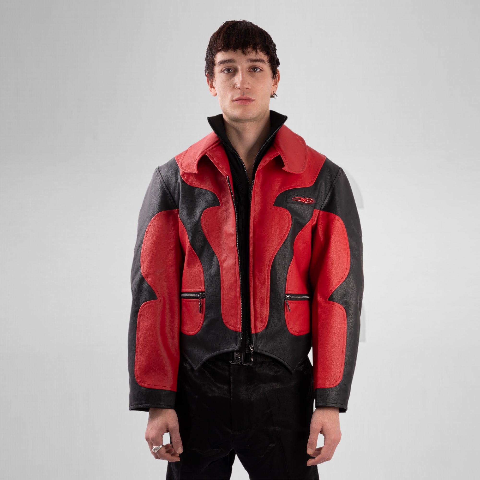 Person wearing a red and black jacket on a gray background