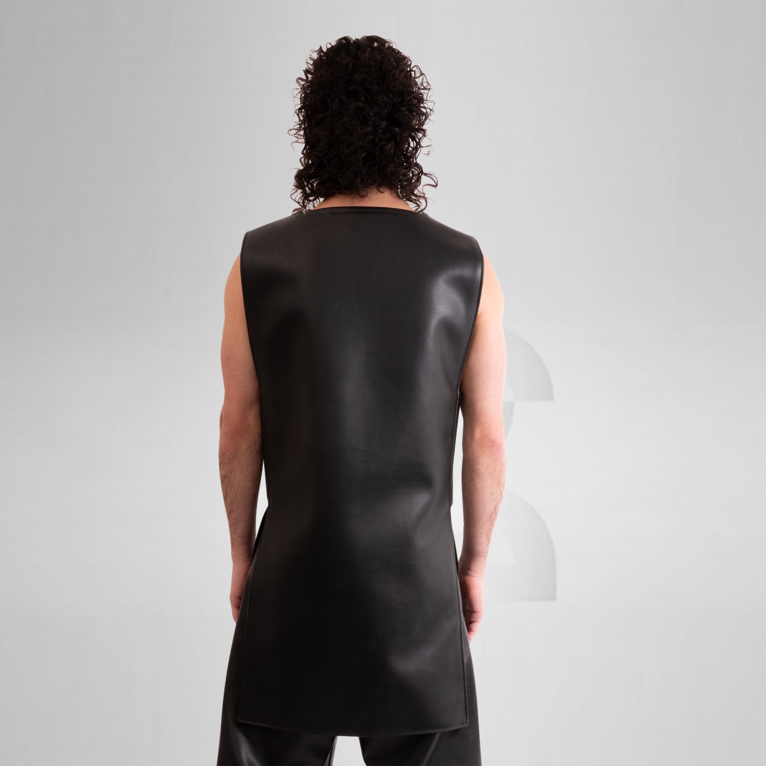 A close-up image of a faux leather vest with an avantgarde geometric design.