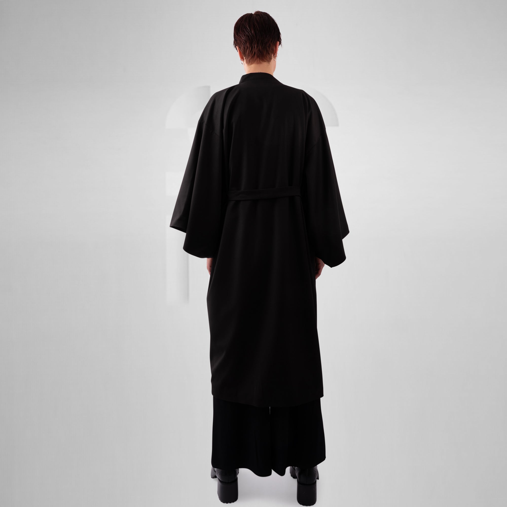 Person wearing a black robe on a white background