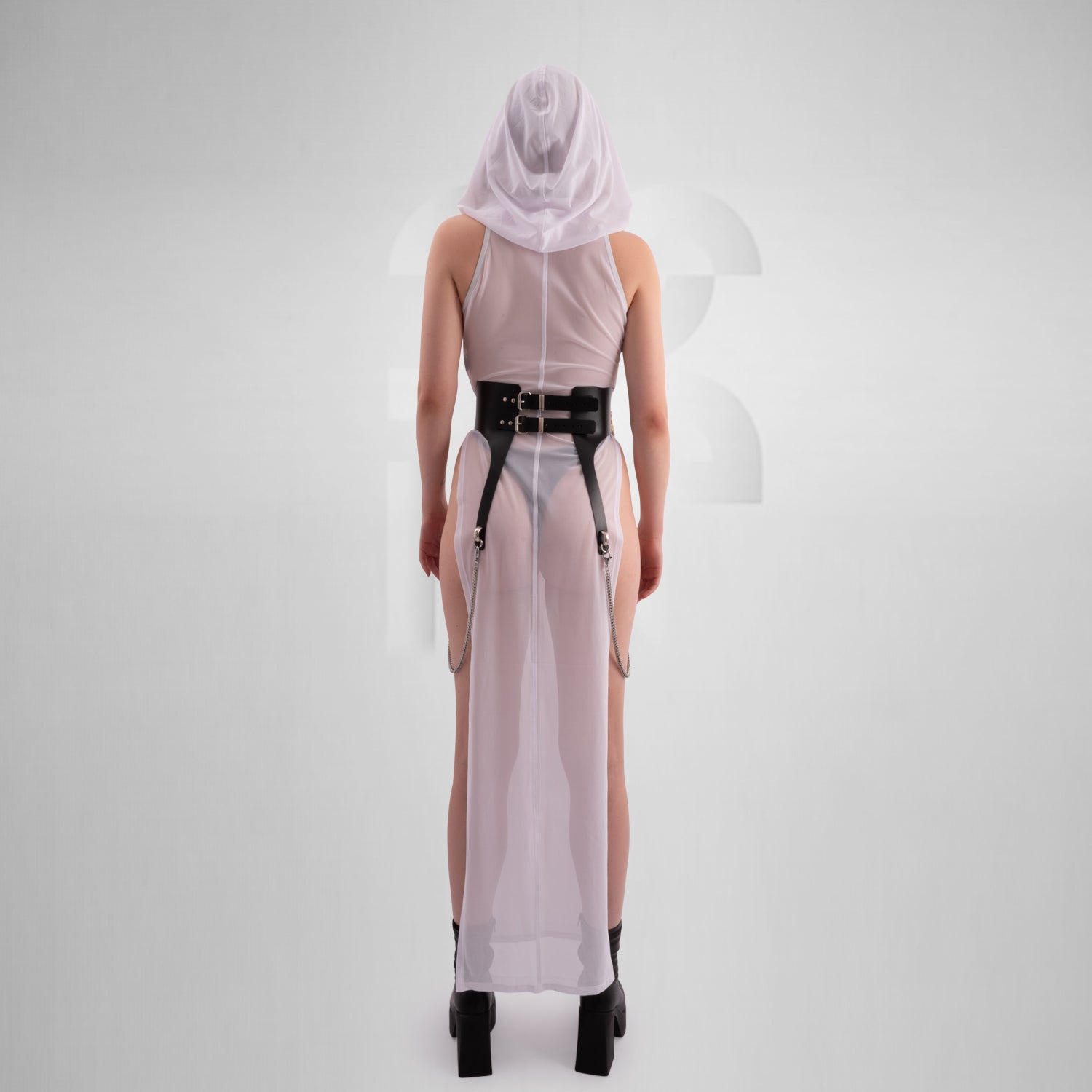 The image features a sheer, long white dress with a high neckline, front zipper, and side slits, paired with chunky black boots. The dress has a futuristic, edgy vibe, combining elegance with boldness.