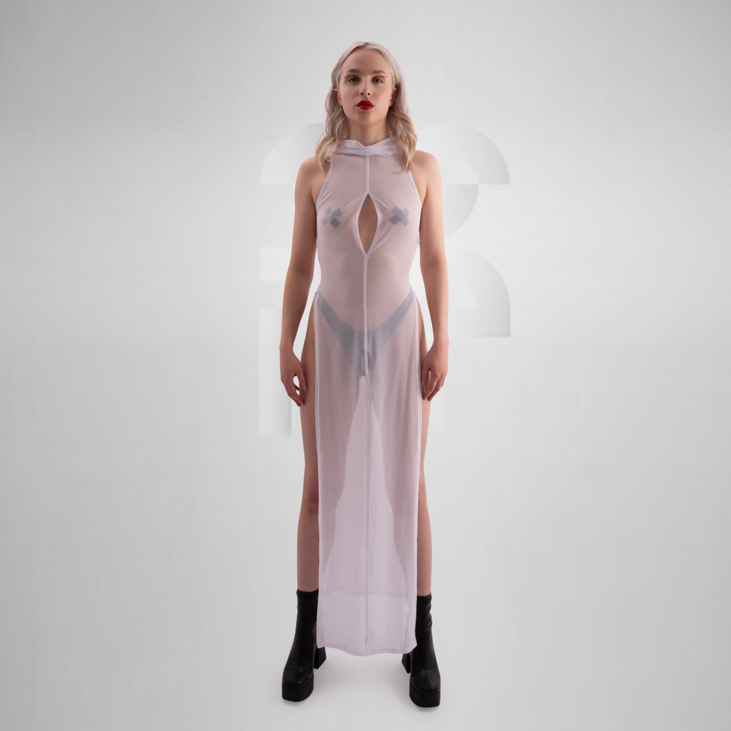 The image features a sheer, long white dress with a high neckline, front zipper, and side slits, paired with chunky black boots. The dress has a futuristic, edgy vibe, combining elegance with boldness.