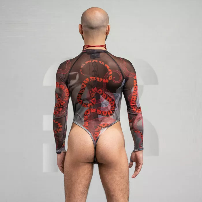 sheer, long-sleeve bodysuit with a striking red and black pattern featuring intricate designs. The form-fitting ensemble showcases bold motifs and a high neckline, offering a daring and artistic look. The neutral background emphasizes the detailed design and unique style of the outfit.