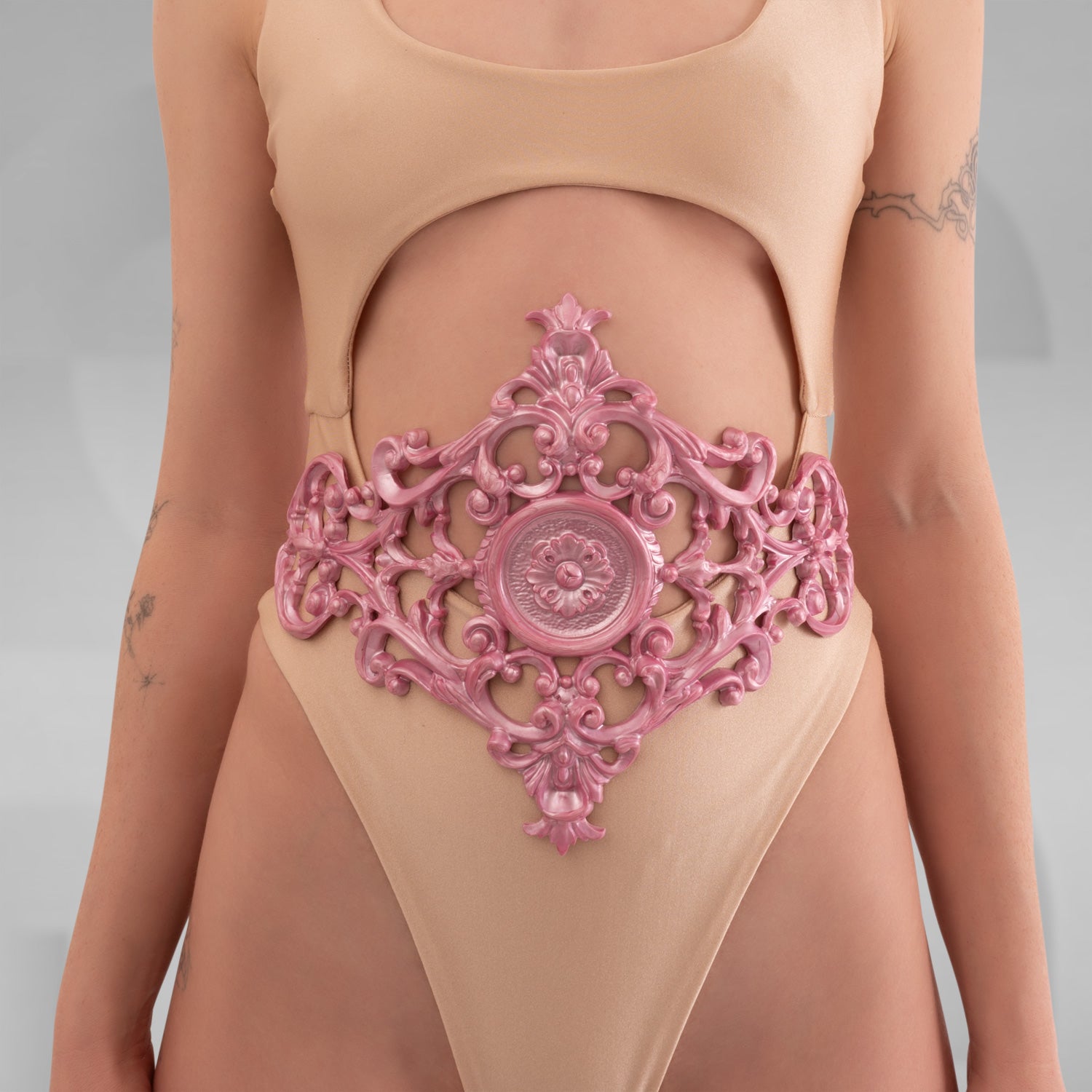 A model showcasing the Baroque 3D Latex Corset in Pink, elegantly displayed against a light grey background. The corset highlights its intricate design and fits the model’s silhouette perfectly, embodying sophistication and baroque charm.