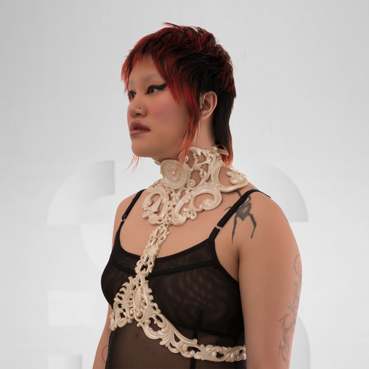 This image showcases a model wearing a striking white harness that features intricate detailing and a bold design. The harness combines artistic elements with a modern aesthetic, beautifully highlighting the model’s figure. Its eye-catching pattern and unique structure make it an ideal statement piece for avant-garde fashion, perfect for nightlife events or elevating casual looks. The overall ensemble exudes confidence and creativity, making it a standout choice for those who love to express their individua