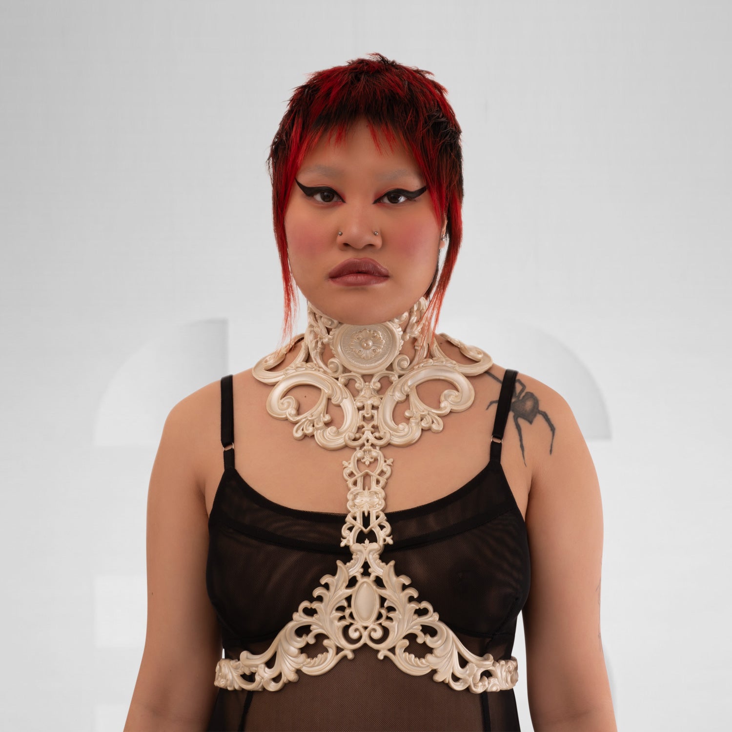 This image showcases a model wearing a striking white harness that features intricate detailing and a bold design. The harness combines artistic elements with a modern aesthetic, beautifully highlighting the model’s figure. Its eye-catching pattern and unique structure make it an ideal statement piece for avant-garde fashion, perfect for nightlife events or elevating casual looks. The overall ensemble exudes confidence and creativity, making it a standout choice for those who love to express their individua