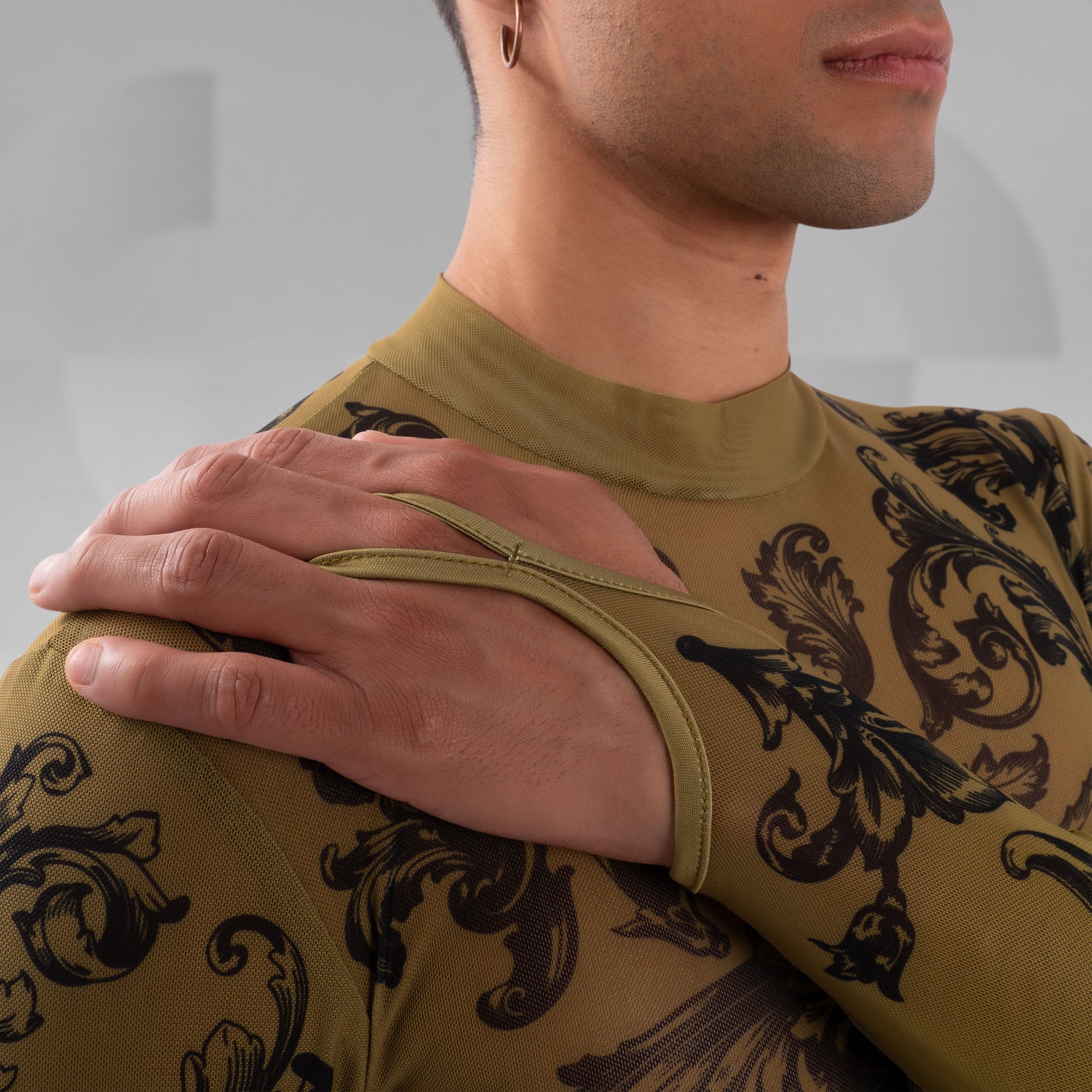 Person wearing a green athletic shirt with black floral patterns