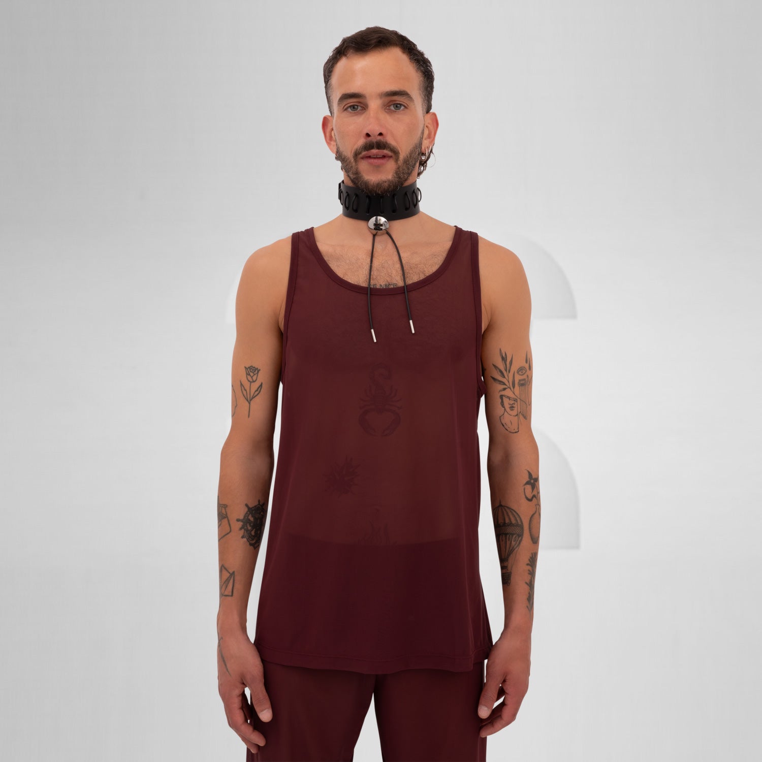 Model wearing a red mesh tank top, embodying Berlin club fashion.