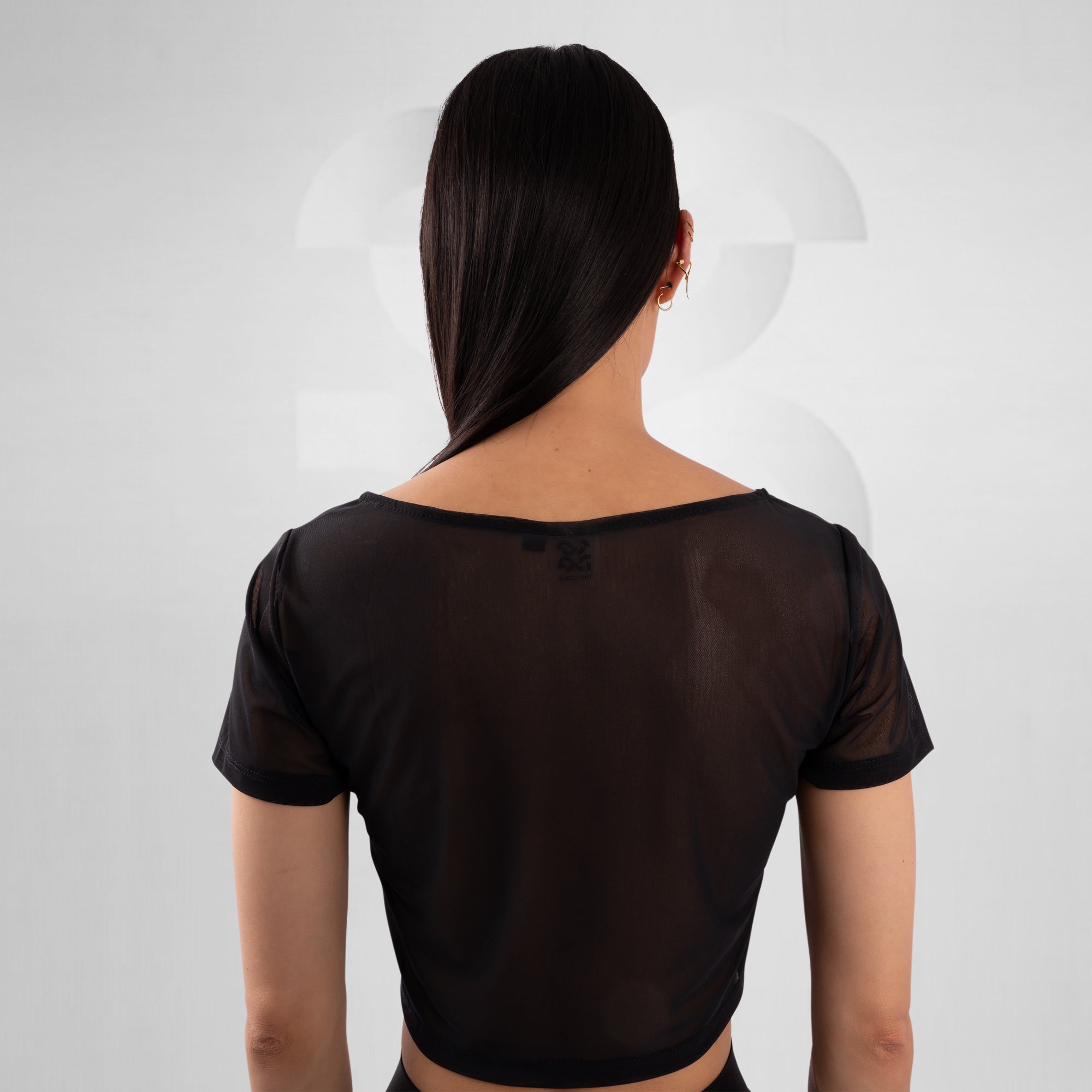 Person wearing a black sheer top on a white background