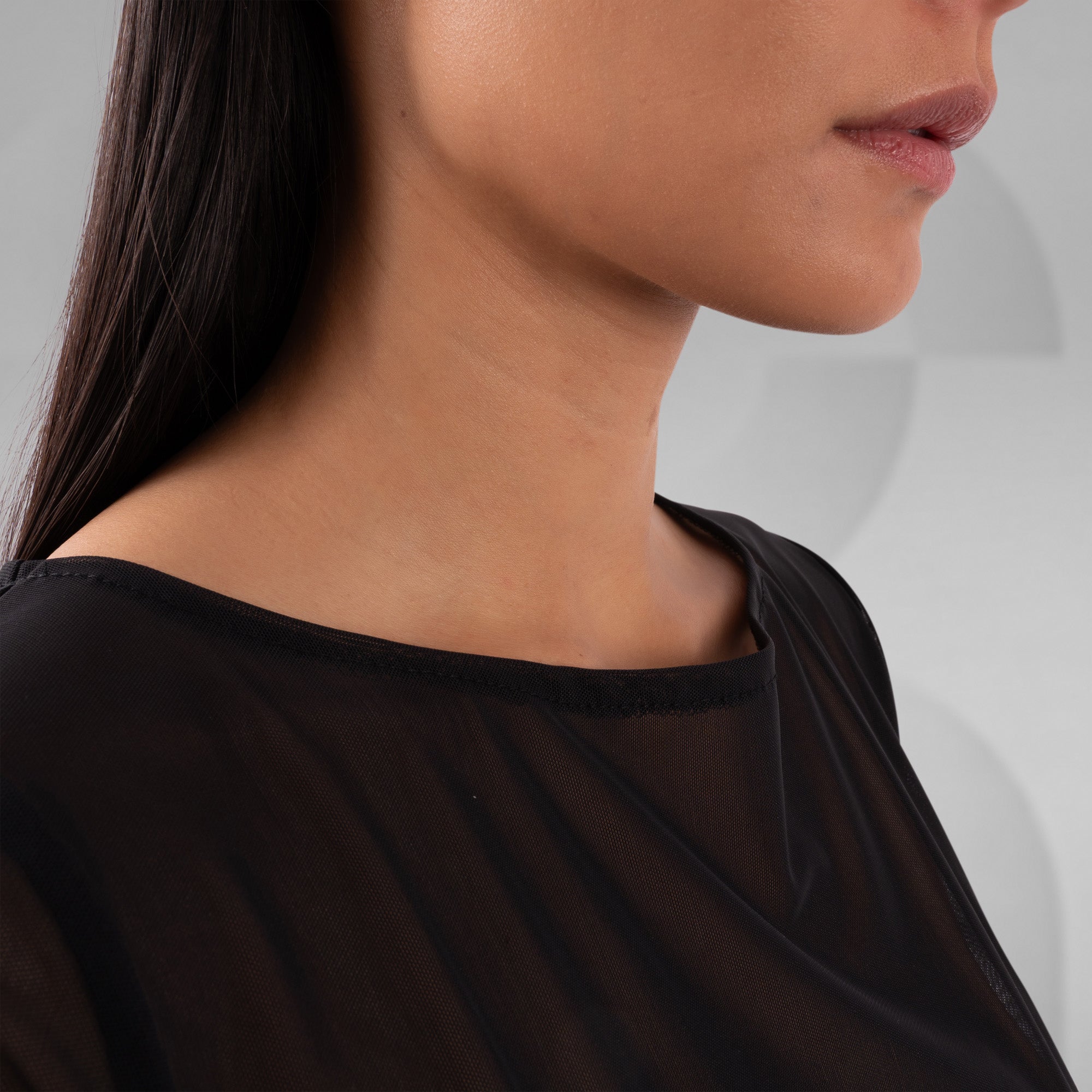 Close-up of a person wearing a black top with a blurred background