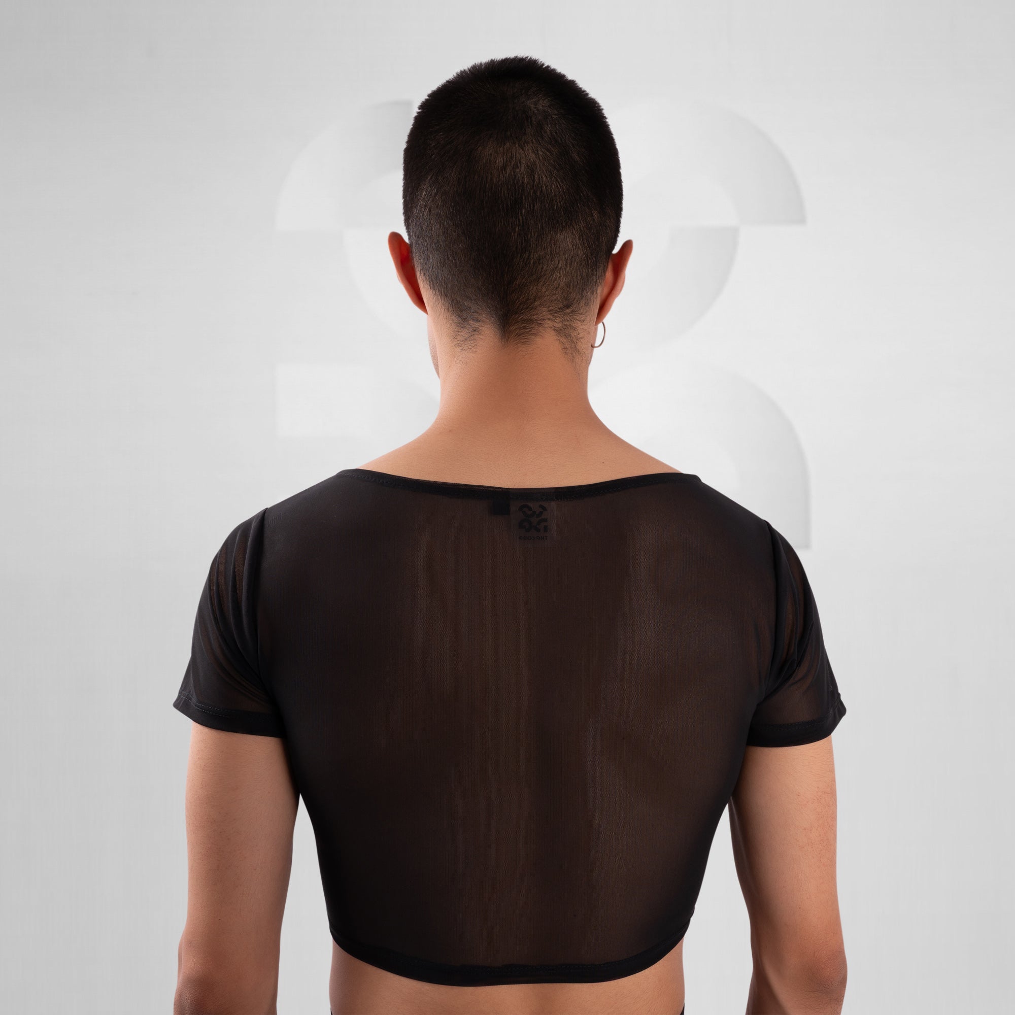 Person wearing a sheer black top on a white background