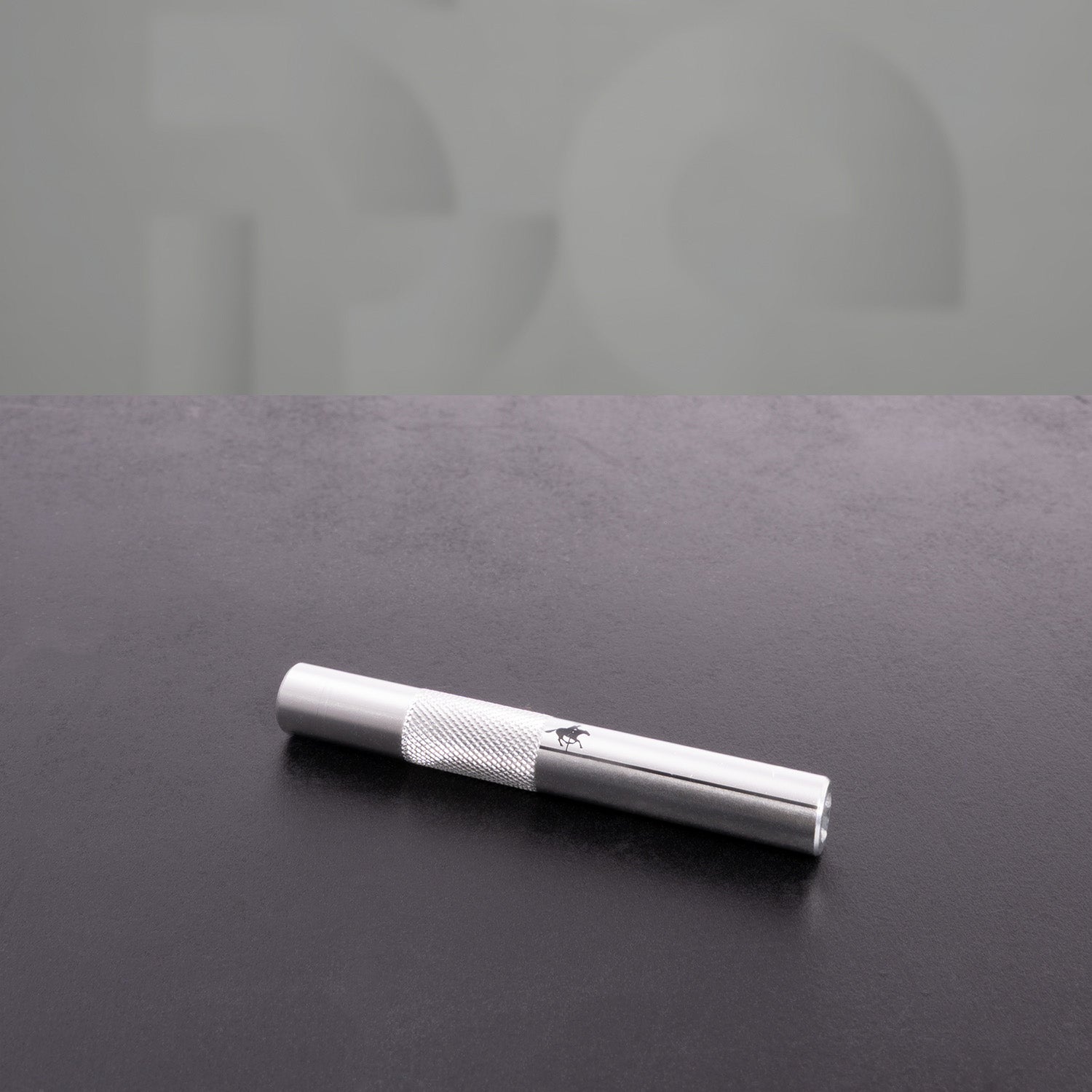 This image features a polished metal straw from "The Code," showcasing a sleek design with a textured grip. Its shiny finish adds a touch of elegance, making it a stylish and functional accessory for any beverage. Perfect for those who appreciate both aesthetics and practicality!