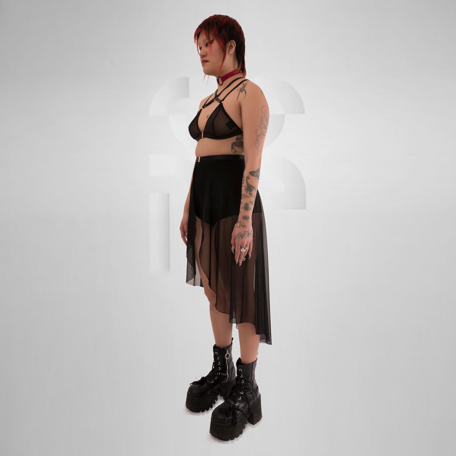 Side view of a sheer, flowing asymmetric Mesh Skirt in Black, equipping you for ruling the night in edgy elegance.