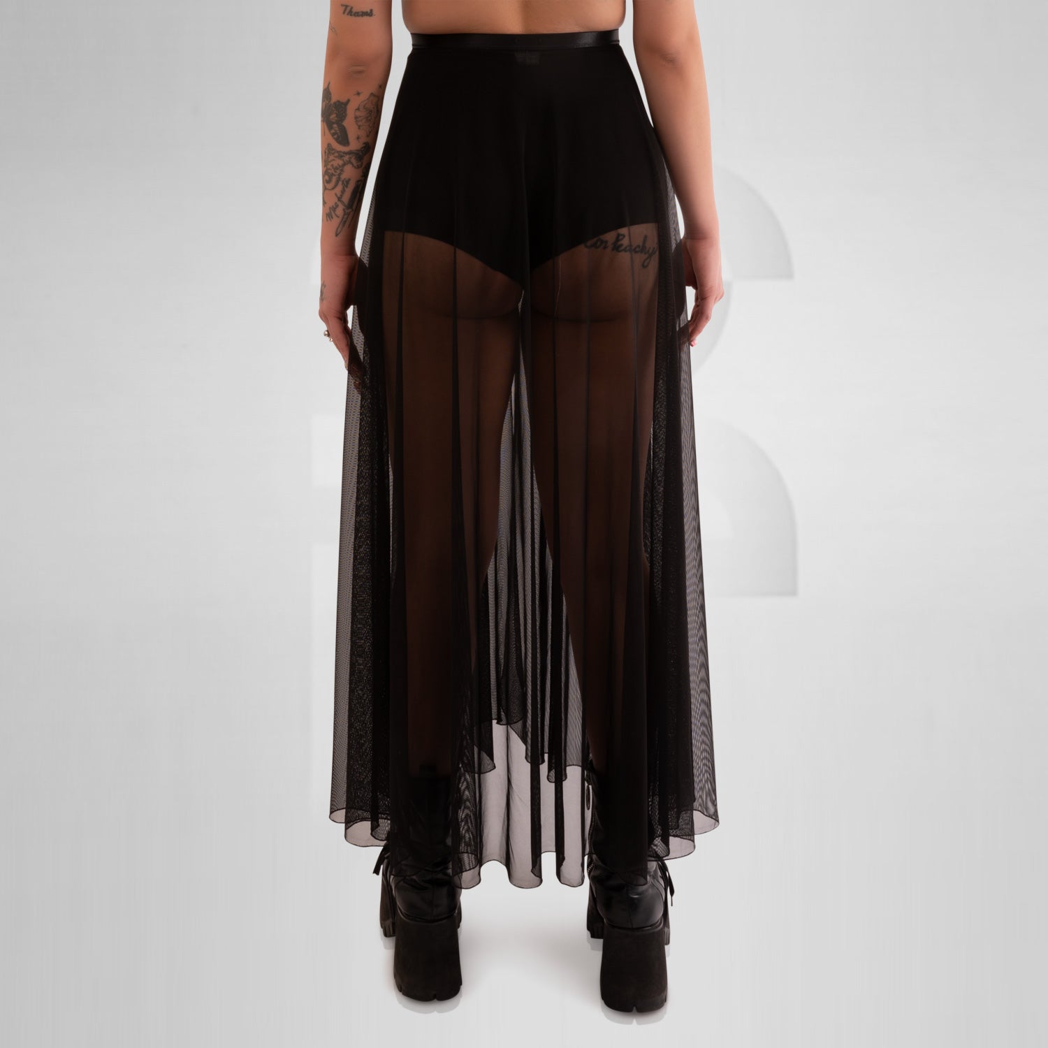 Long mesh skirt with front split and seductive appeal, creating a visually arresting piece that demands attention. Its long length gracefully flows down to the floor, providing a captivating and sophisticated look. The fabric embraces the wearer's curves, accentuating her feminine shape while remaining comfortable to wear.