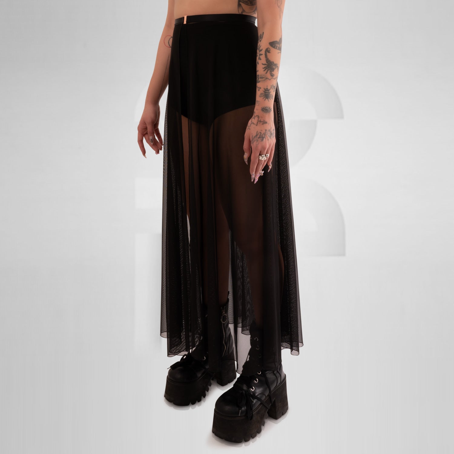 Long mesh skirt with front split and seductive appeal, creating a visually arresting piece that demands attention. Its long length gracefully flows down to the floor, providing a captivating and sophisticated look. The fabric embraces the wearer's curves, accentuating her feminine shape while remaining comfortable to wear.
