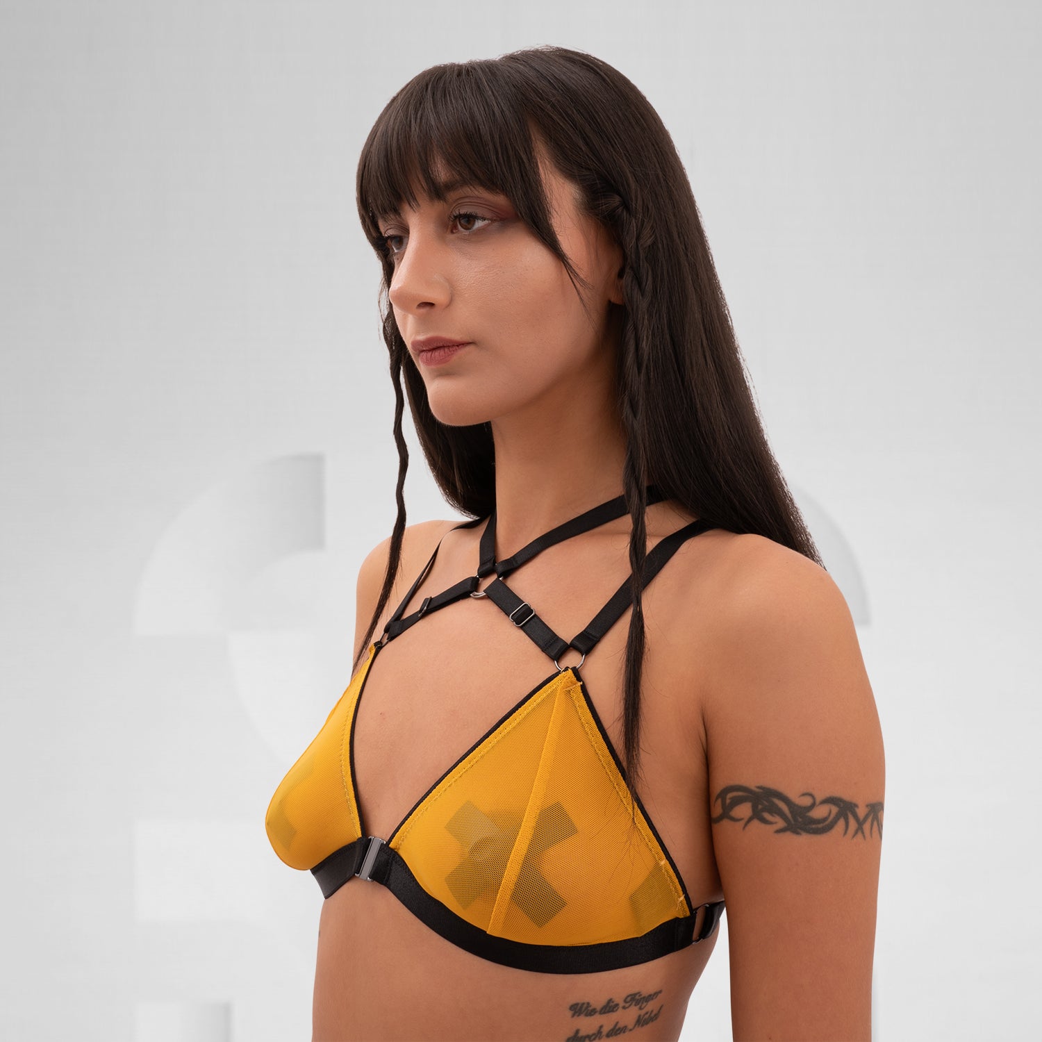 The Strappy Mesh Bra from Tight Laced is a captivating blend of edgy design and sensual appeal. Featuring a vibrant yellow mesh and bold black straps, this triangle bra offers a daring look that fuses lingerie with clubwear. The adjustable straps provide a customizable fit, ensuring both comfort and style. Ideal for fashion-forward individuals looking to make a statement at festivals or during nights out, this bra is perfect for embracing your unique style while keeping it playful and chic.