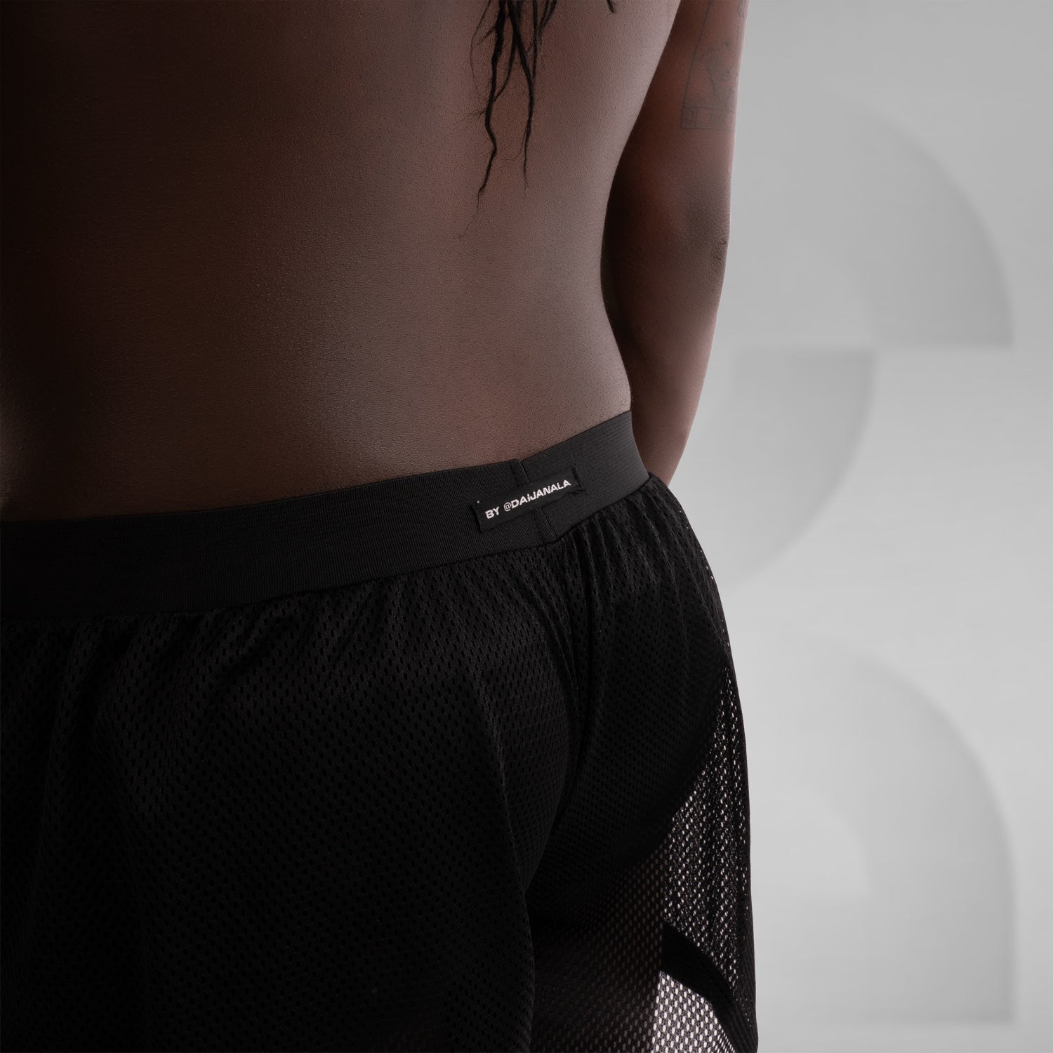 A pair of black net shorts for men, ideal for the techno scene, providing both style and comfort.