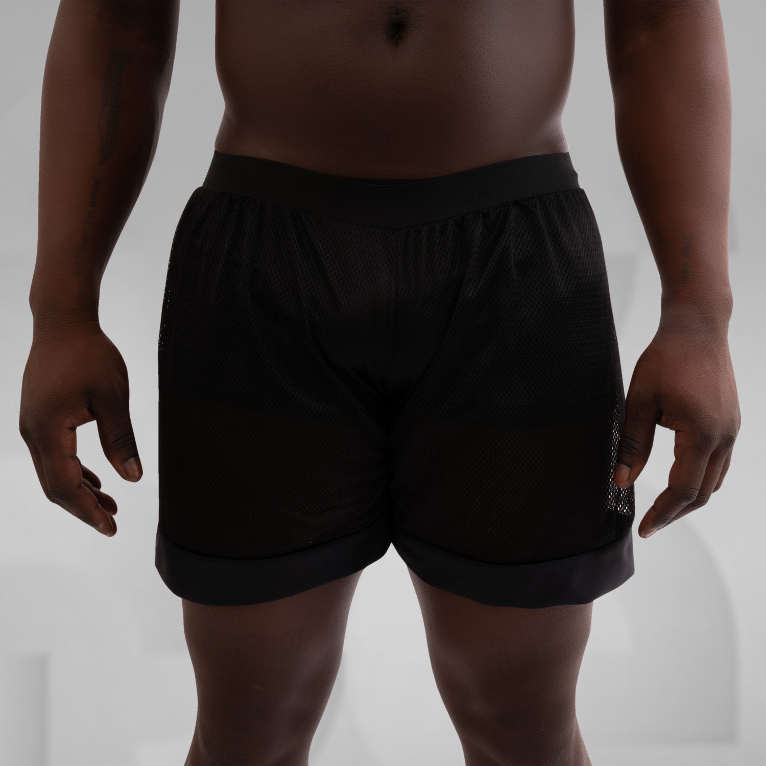 A pair of black net shorts for men, ideal for the techno scene, providing both style and comfort.