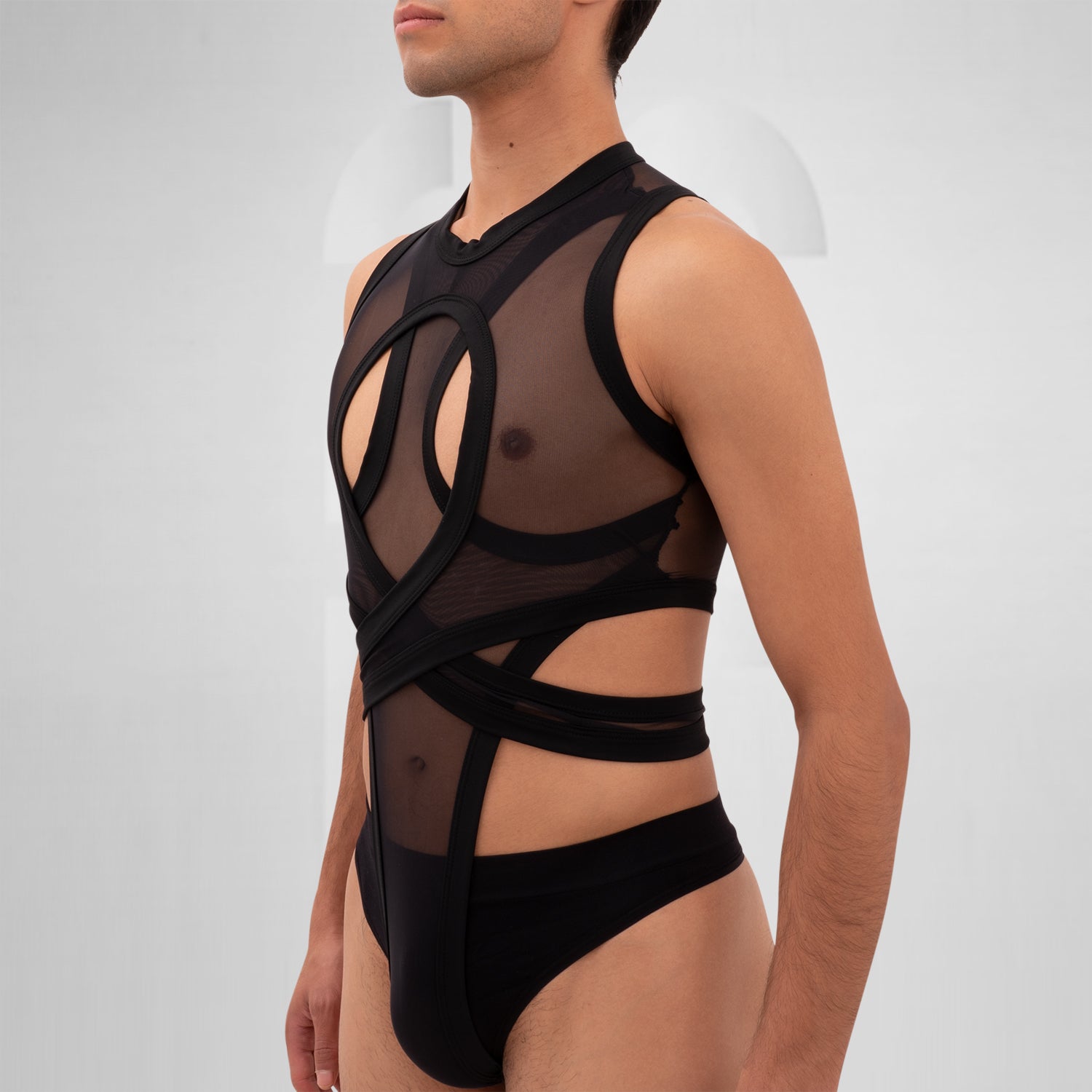 The Bound Gender-Neutral Meshed Bodysuit from Berlin designer Nur Hektor is a striking blend of edgy aesthetics and avant-garde fashion. Featuring sheer mesh and bold cut-out details, this unique piece embraces a daring silhouette perfect for festivals and clubwear. The innovative wraparound design not only highlights your figure but also allows for expressive individuality.