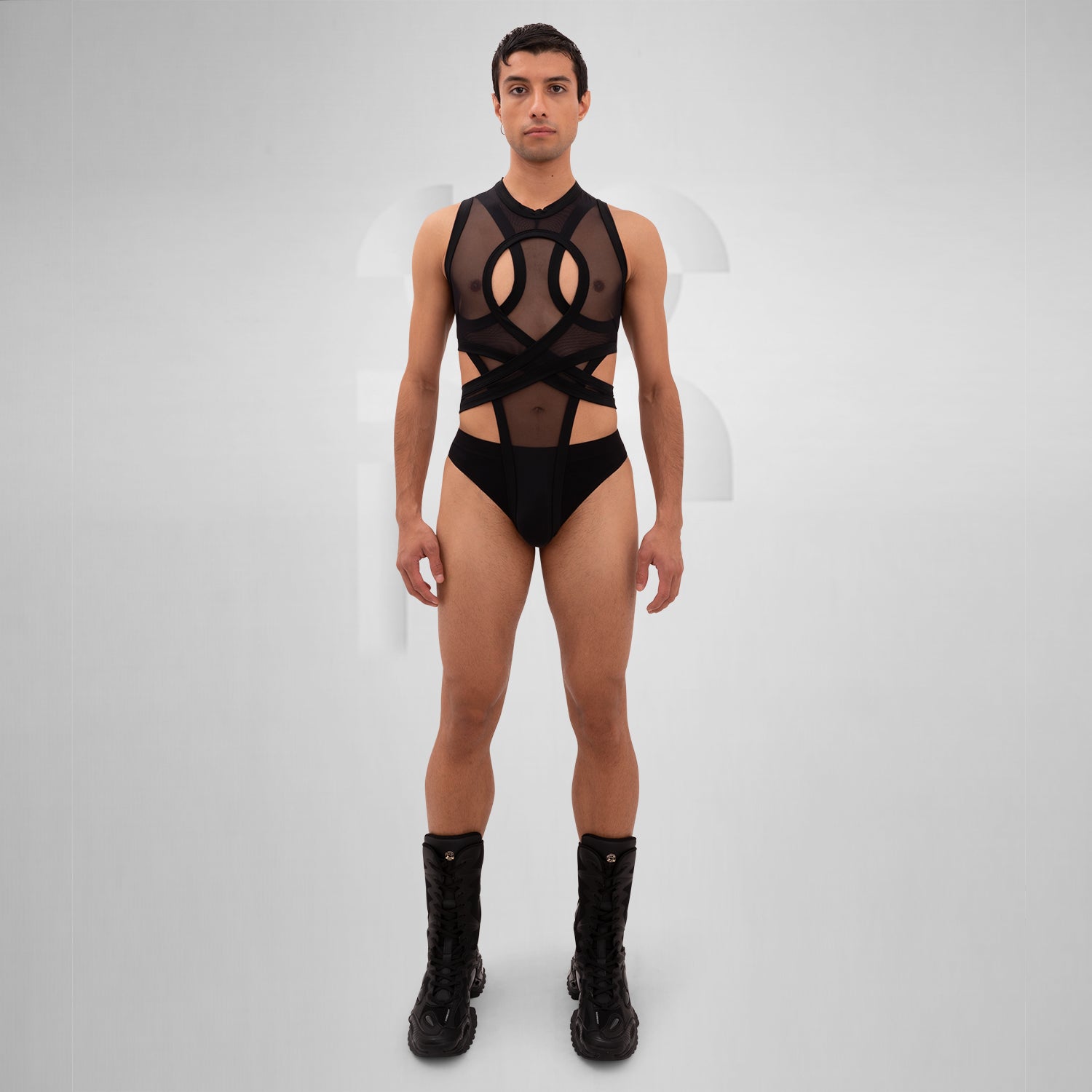 The Bound Gender-Neutral Meshed Bodysuit from Berlin designer Nur Hektor is a striking blend of edgy aesthetics and avant-garde fashion. Featuring sheer mesh and bold cut-out details, this unique piece embraces a daring silhouette perfect for festivals and clubwear. The innovative wraparound design not only highlights your figure but also allows for expressive individuality.
