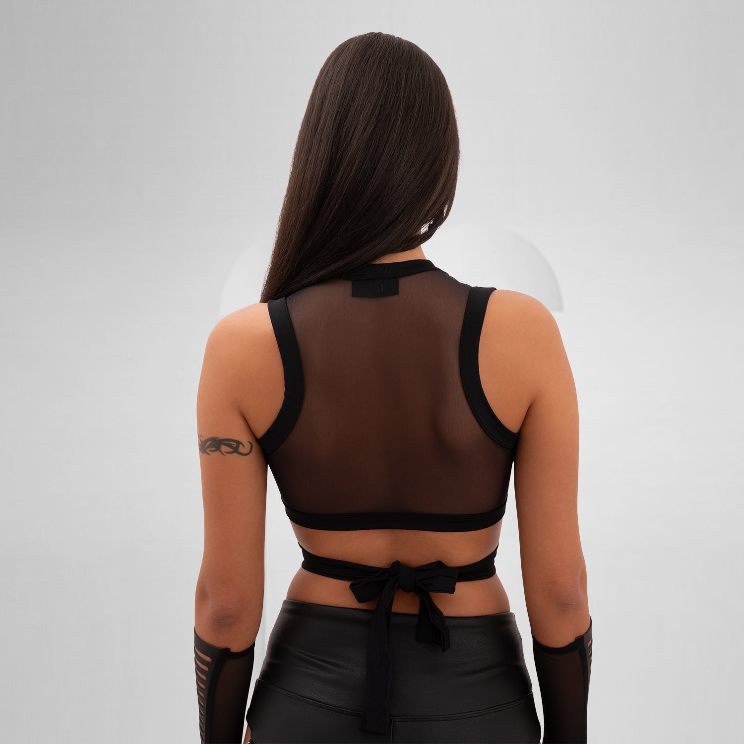 Introducing the Bound Gender-Neutral Mesh Top from Berlin designer Nur Hektor. This avant-garde piece combines sheer mesh with a daring wraparound design, making it perfect for festivals and clubwear. The striking cut-out detail offers a bold yet stylish silhouette, allowing for expressive individuality and a unique fashion statement.