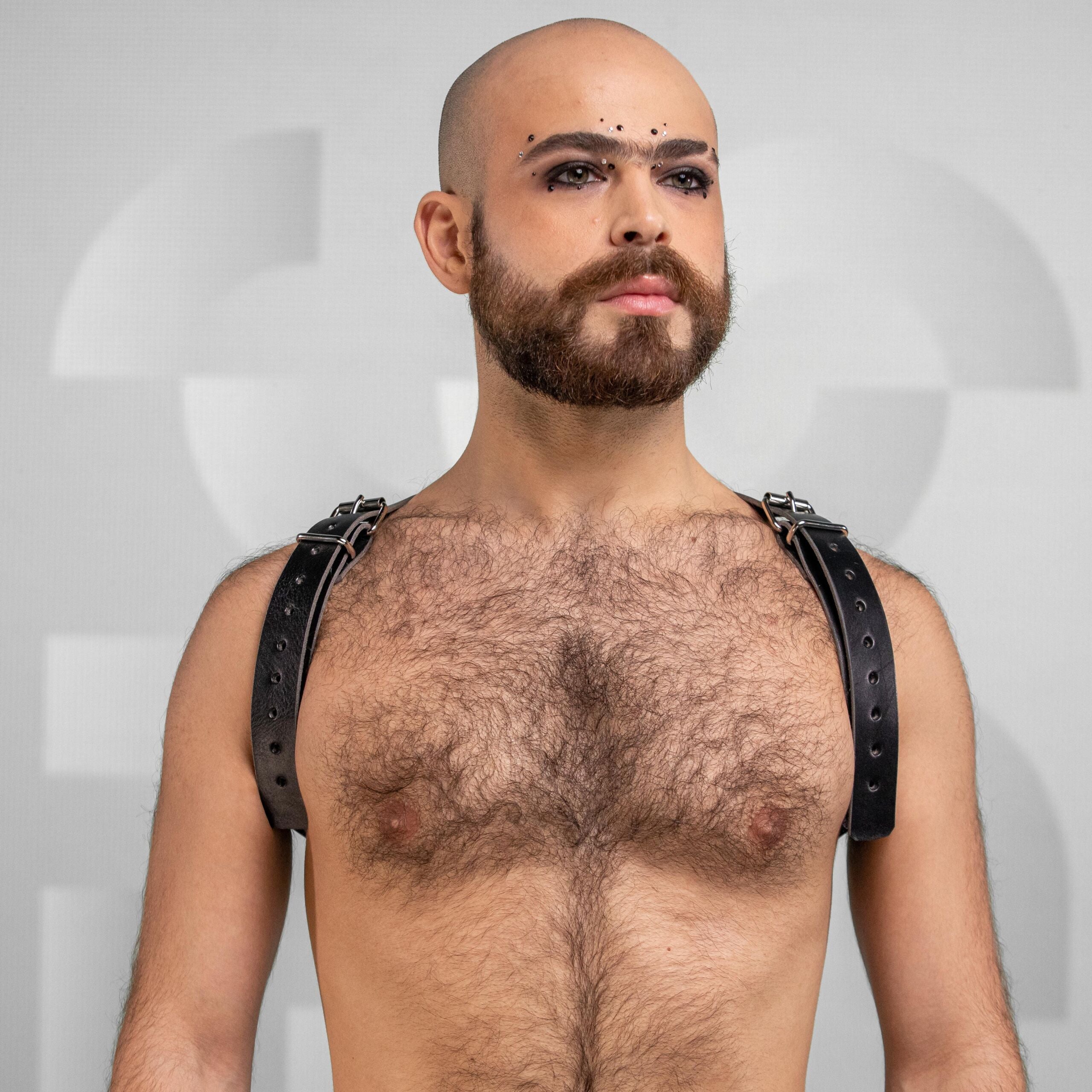 Bold, versatile unisex leather shoulder harness with cross-back design and dual buckles.