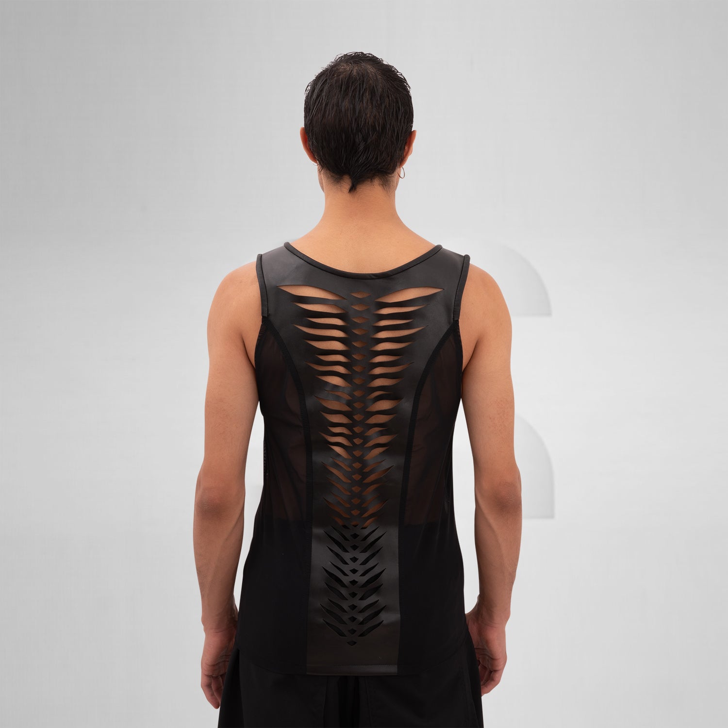 The Cutting Edge Vegan Leather Mesh Tanktop from Cyberesque blends sleek vegan leather with mesh panels for a dynamic look. This tank top offers a modern, edgy style perfect for tribal festivals or avant-garde street fashion. Its minimalist design exudes sophistication, making it an ideal choice for anyone looking to make a bold statement. Wear it to showcase your unique fashion sense with confidence.