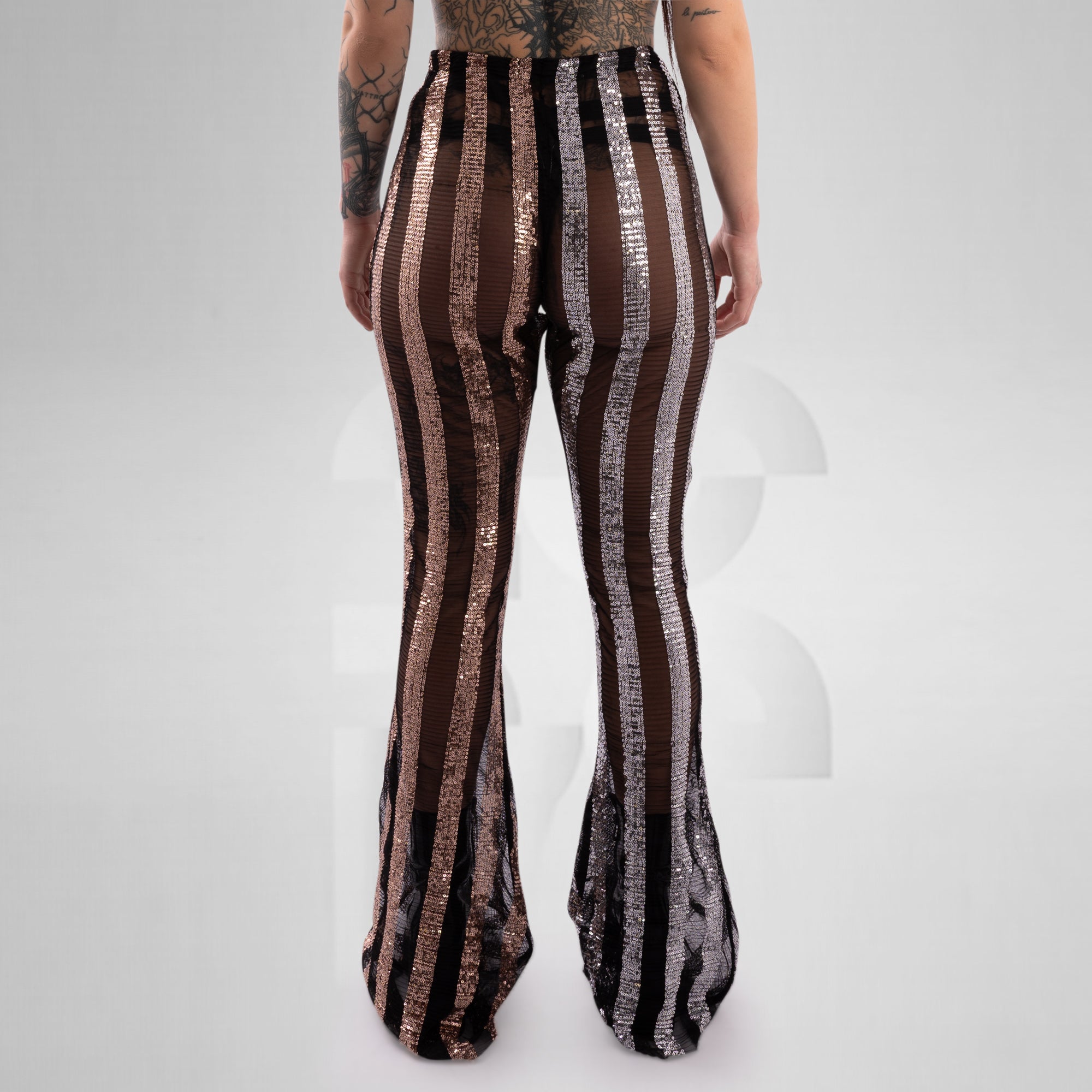 Person wearing black and brown striped pants on a white background