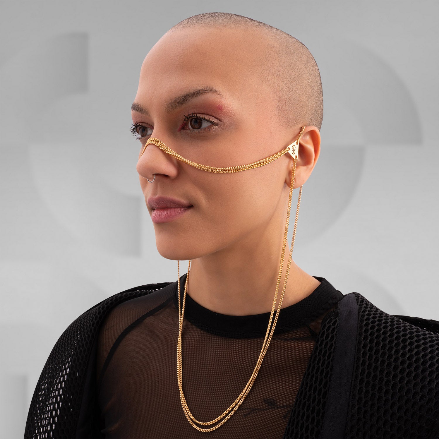 This image showcases a stunning gold face chain that elegantly drapes across the wearer’s features, accentuating their style with a touch of glamour. Paired with a chic mesh top and modern accessories, this look perfectly combines edginess and sophistication. It’s a versatile statement piece, ideal for festivals, nightlife, or daily street fashion.