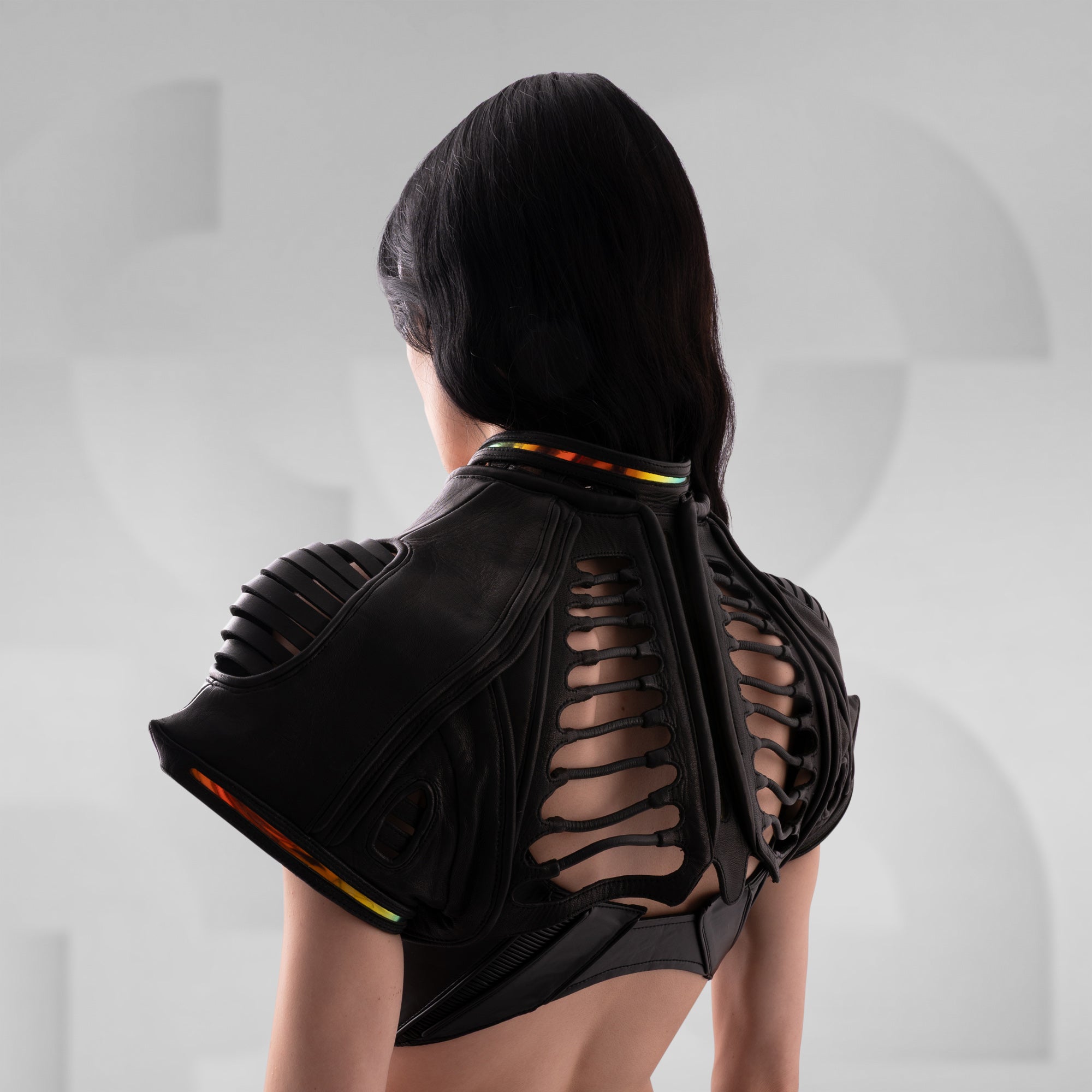 Black lace-up top worn by a person on a light gray background