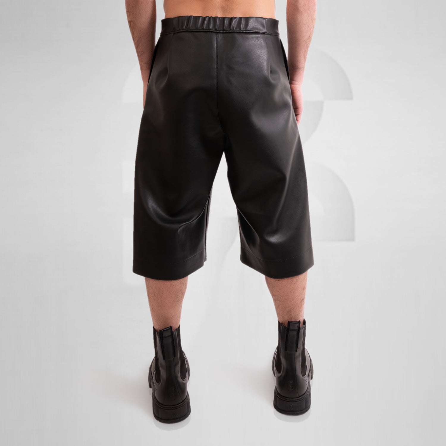Image of a pair of avant-garde faux leather pants with a unique layered geometric style.