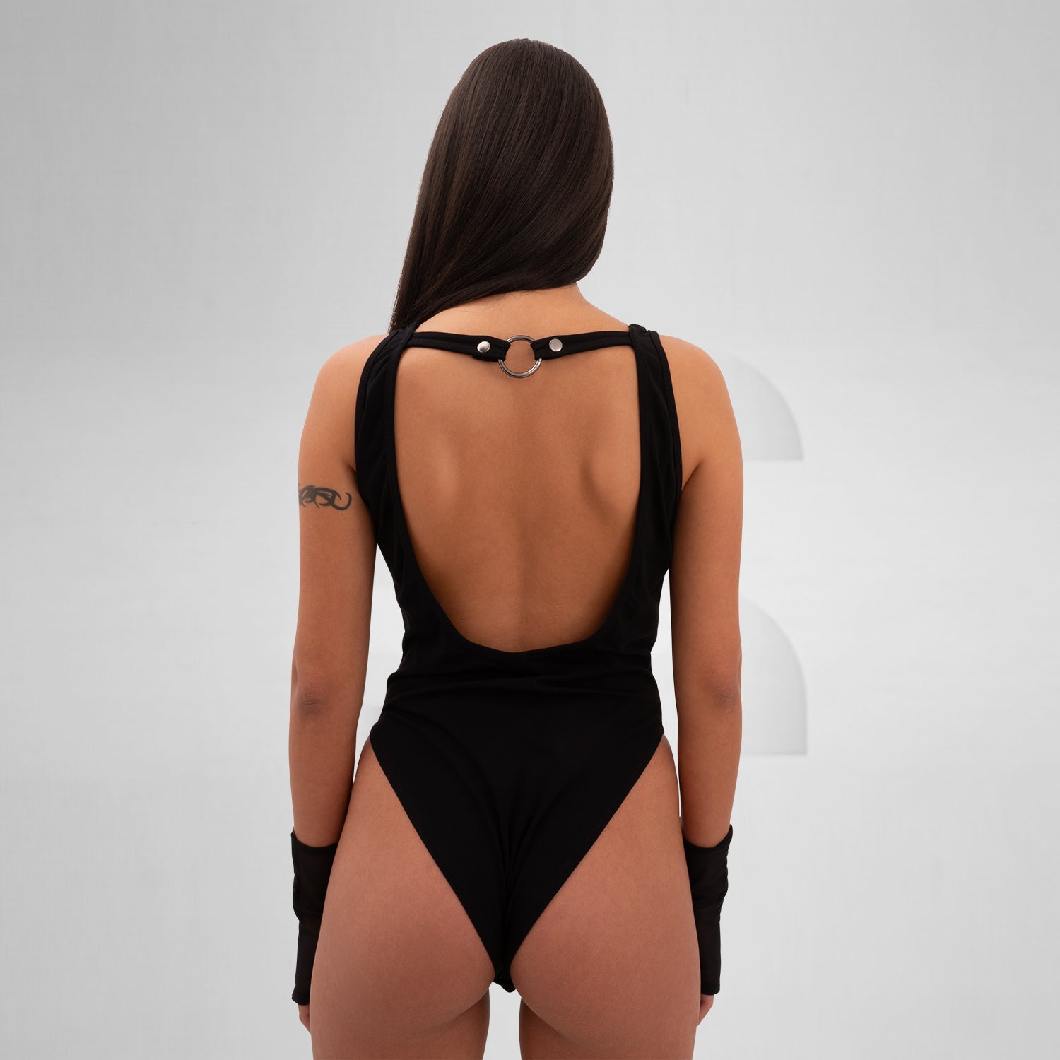 Avant-garde body crafted from cotton, faux leather, and elastane, featuring bold straps, sleek design, and discreet snap closures.