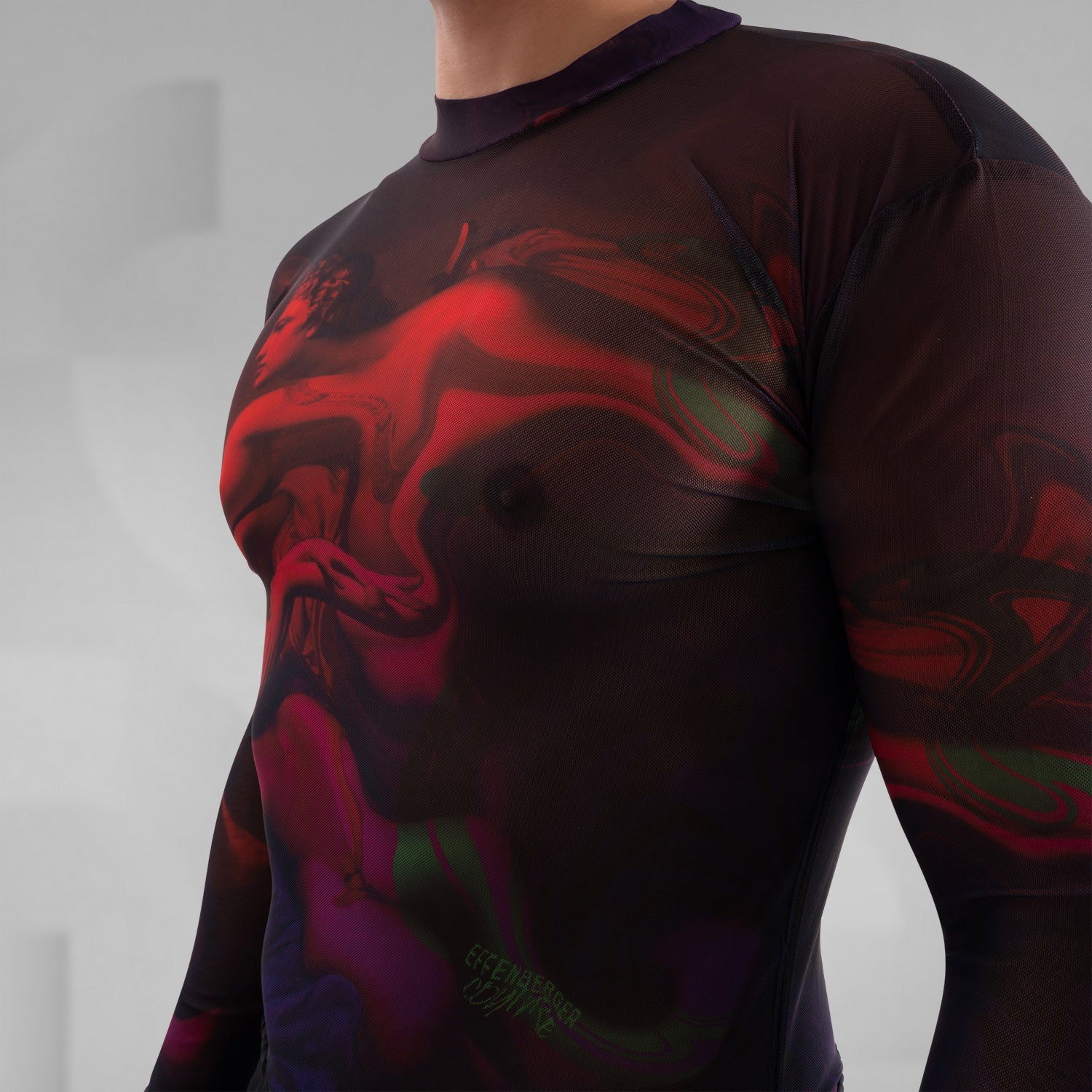 The image features a striking outfit showcasing a long-sleeve top with a captivating abstract design in rich hues of red and purple. Its unique metallic neck detail adds an edgy touch, perfectly complementing the bold, artistic style. The top is paired with eye-catching shorts featuring reflective panels, creating a dynamic look that's perfect for standing out. This ensemble is ideal for nightlife events or fashion-forward gatherings, exuding confidence and individuality while embracing a modern aesthetic.