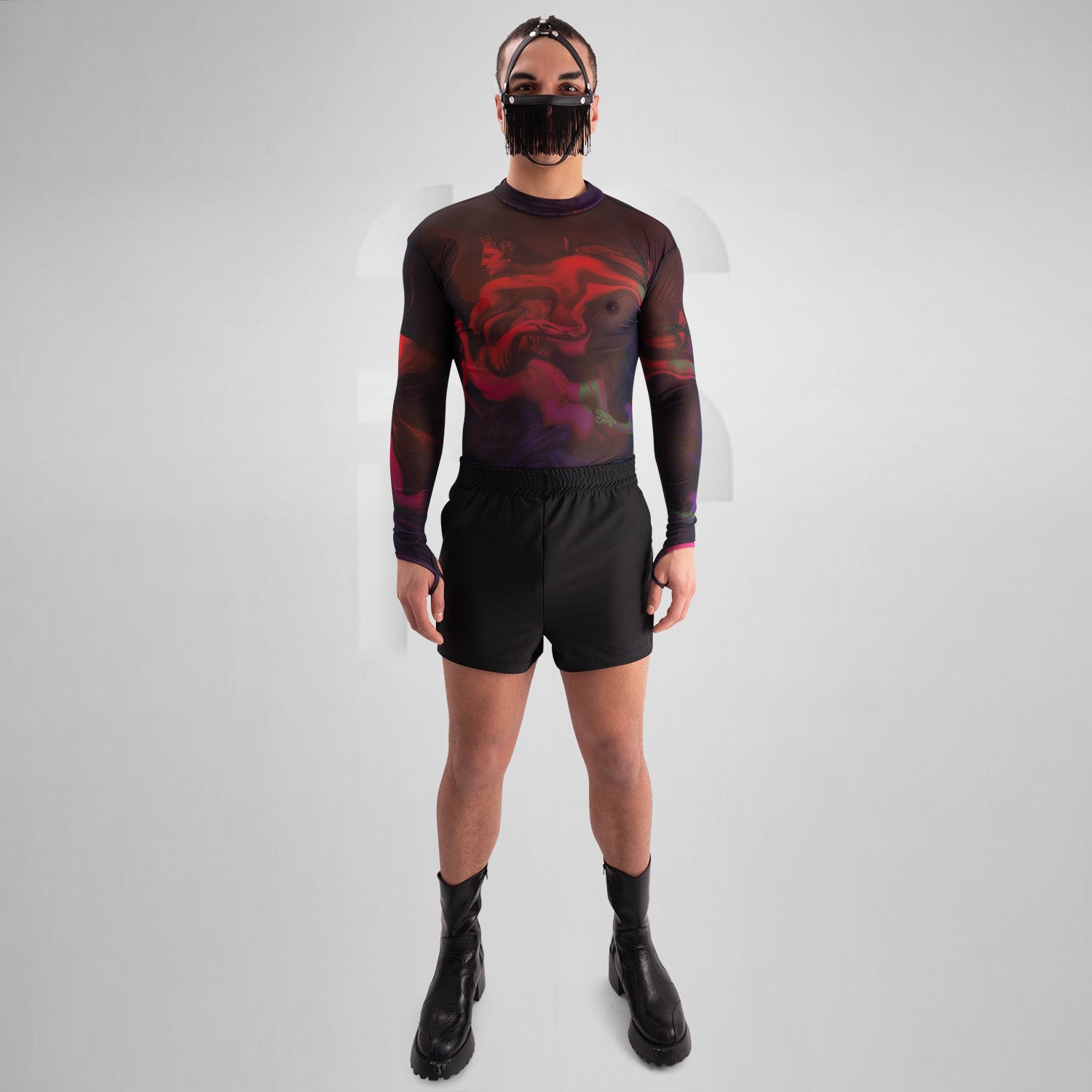 The image features a striking outfit showcasing a long-sleeve top with a captivating abstract design in rich hues of red and purple. Its unique metallic neck detail adds an edgy touch, perfectly complementing the bold, artistic style. The top is paired with eye-catching shorts featuring reflective panels, creating a dynamic look that's perfect for standing out. This ensemble is ideal for nightlife events or fashion-forward gatherings, exuding confidence and individuality while embracing a modern aesthetic.