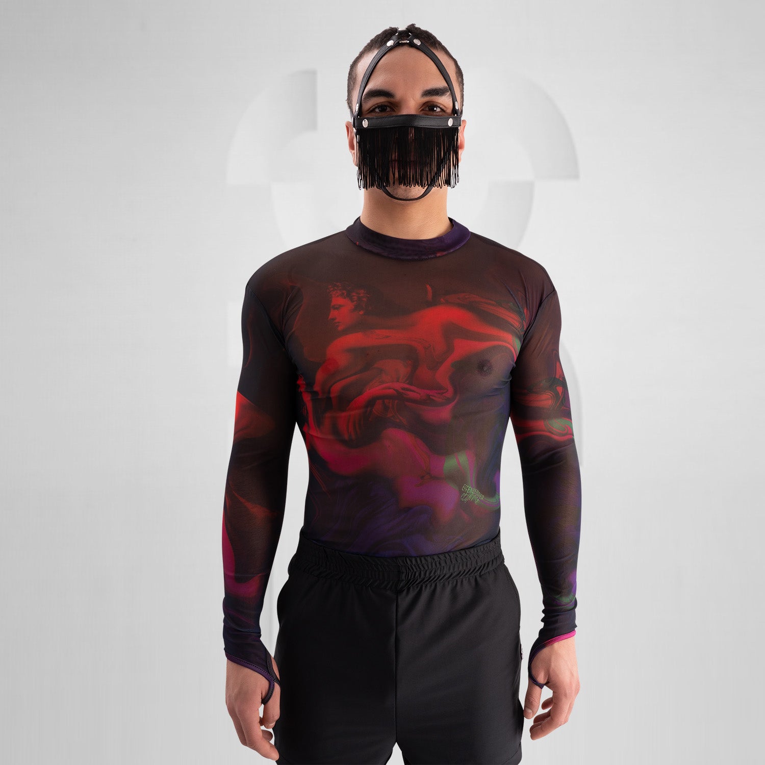 The image features a striking outfit showcasing a long-sleeve top with a captivating abstract design in rich hues of red and purple. Its unique metallic neck detail adds an edgy touch, perfectly complementing the bold, artistic style. The top is paired with eye-catching shorts featuring reflective panels, creating a dynamic look that's perfect for standing out. This ensemble is ideal for nightlife events or fashion-forward gatherings, exuding confidence and individuality while embracing a modern aesthetic.