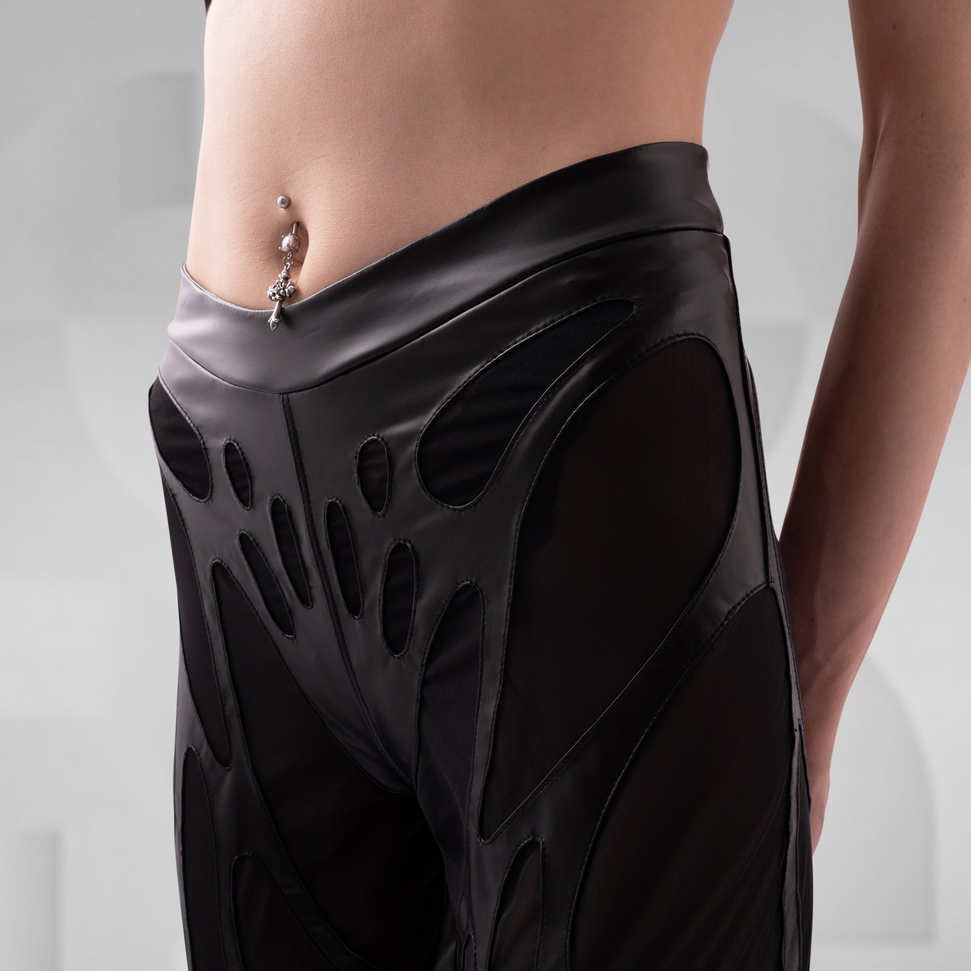 Black, futuristic-looking skirt worn by a person on a plain background