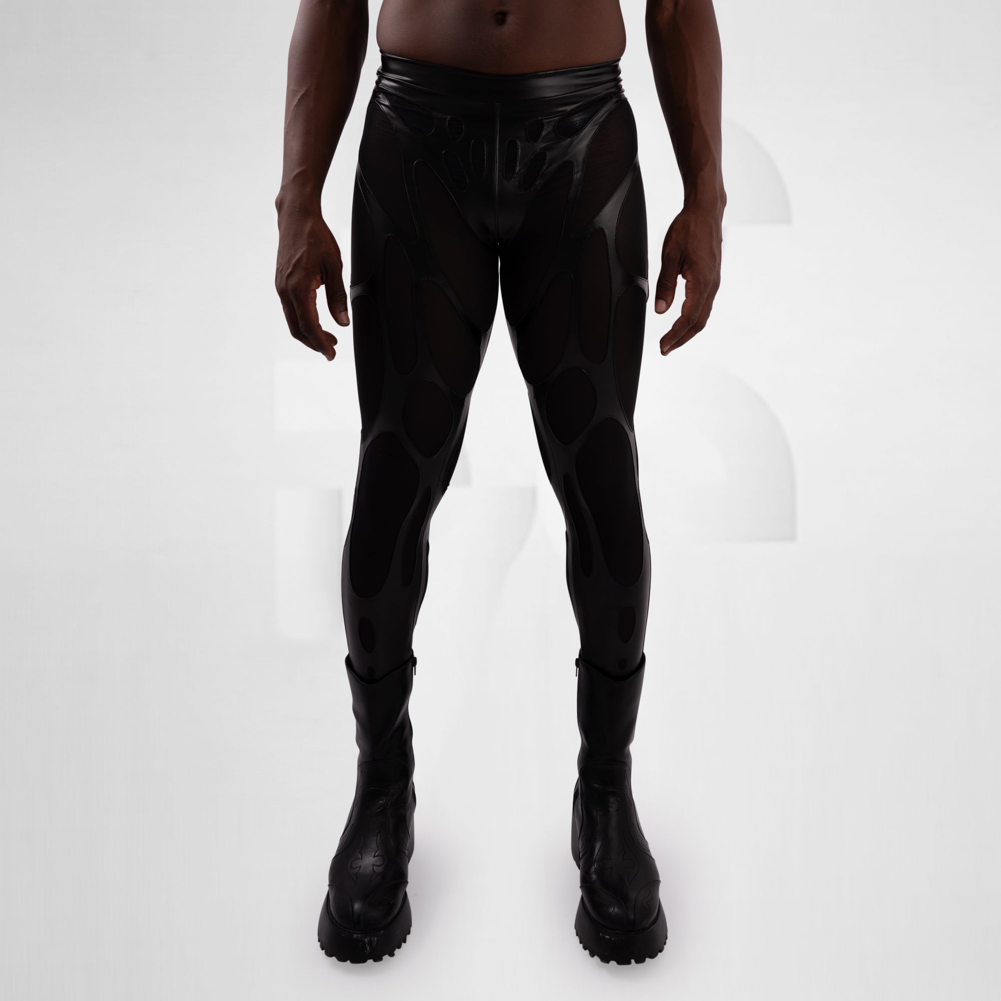 Person wearing black leather pants and boots on a white background