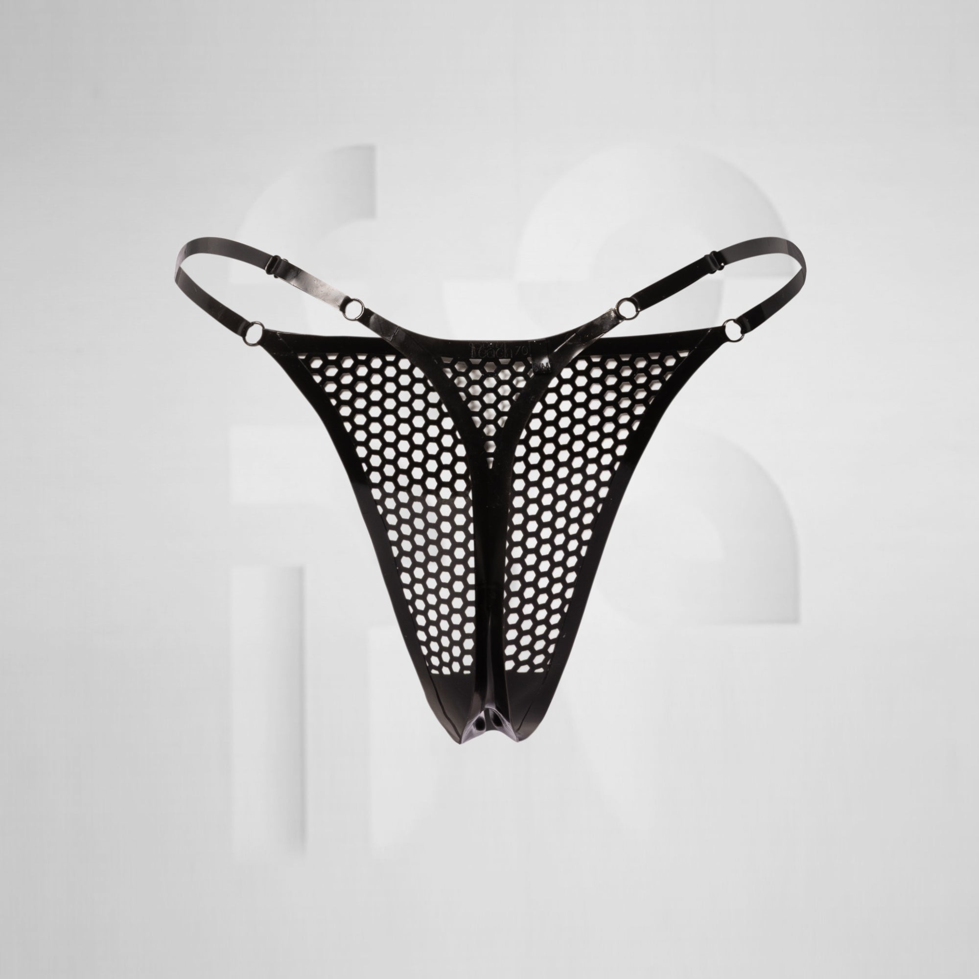 black latex thong in front of grey background