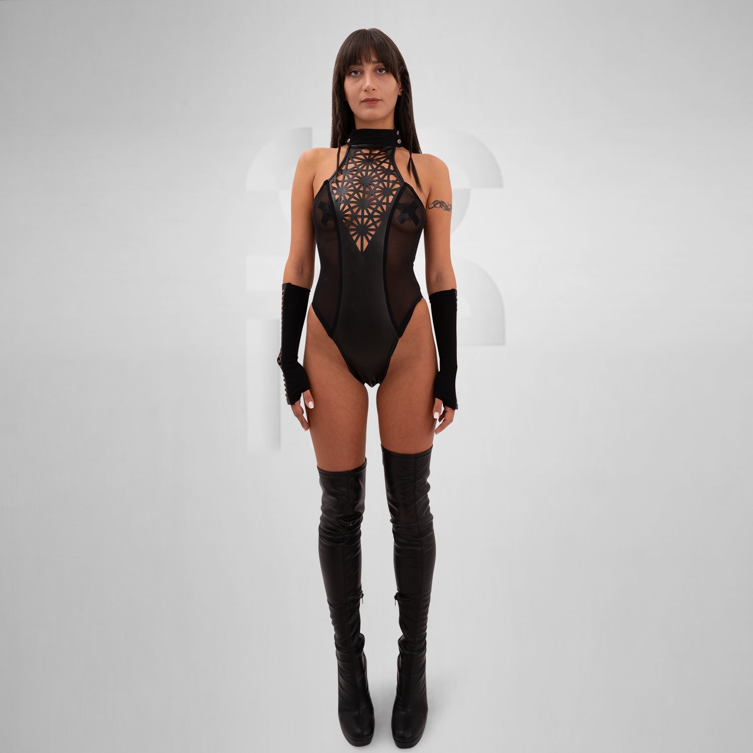 The Printed Sheer Bodysuit from Cyberesque is a striking combination of elegance and bold design. Featuring intricate laser-cut patterns that create a stunning visual impact, this bodysuit perfectly balances allure with avant-garde aesthetics. The sheer fabric elegantly hugs your curves, making it ideal for festivals, clubwear, or glamorous nights out. Complete with stylish long sleeves, this piece elevates your look, allowing you to express your unique style with confidence.