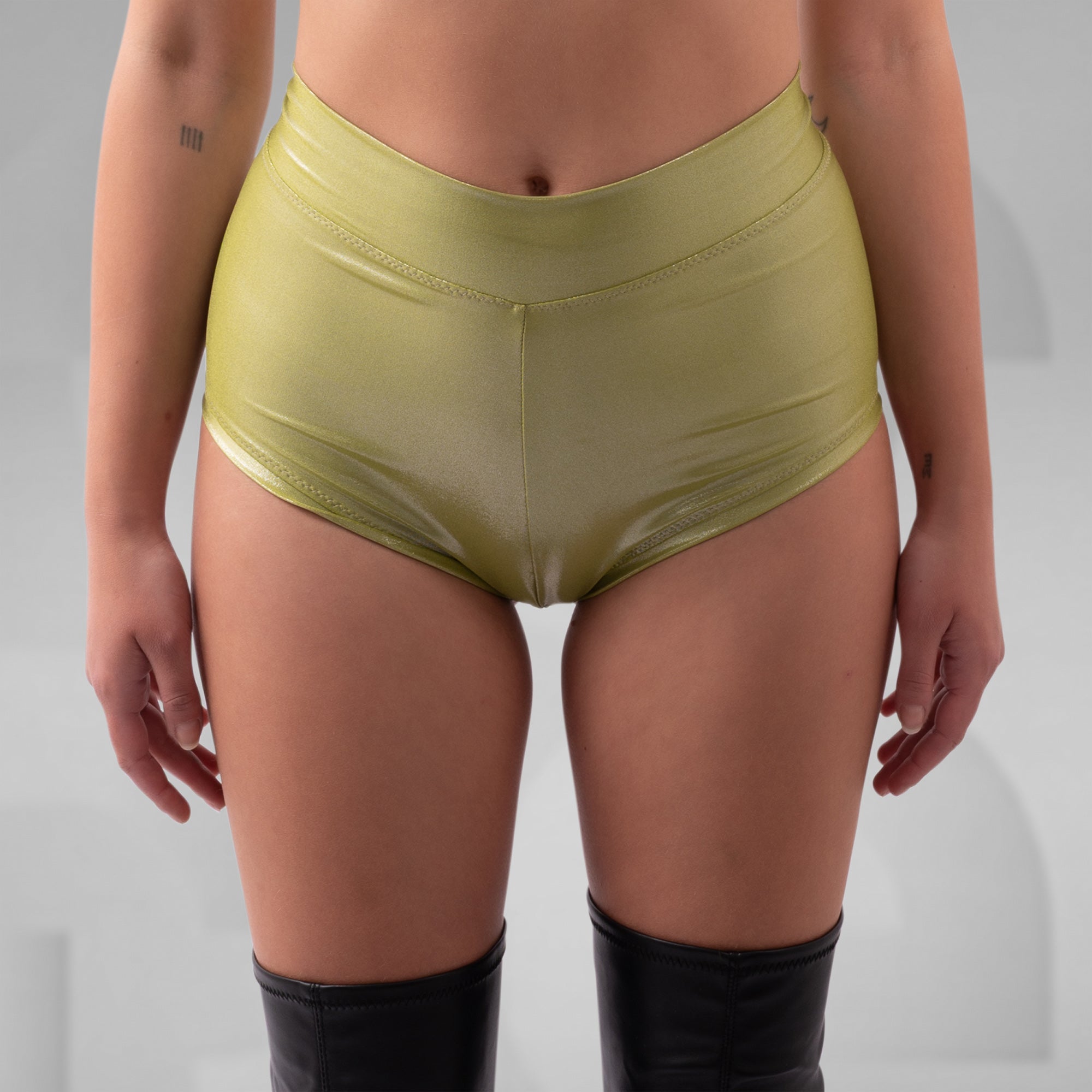 Person wearing green high-waisted underwear on a plain background