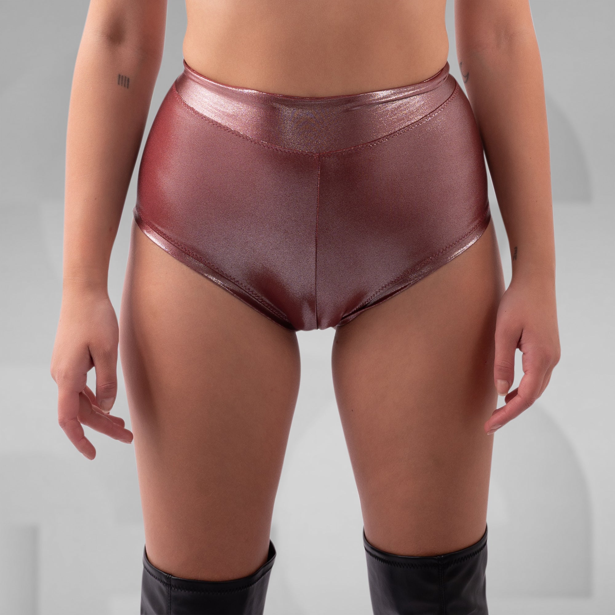 Person wearing shiny maroon underwear on a gray background