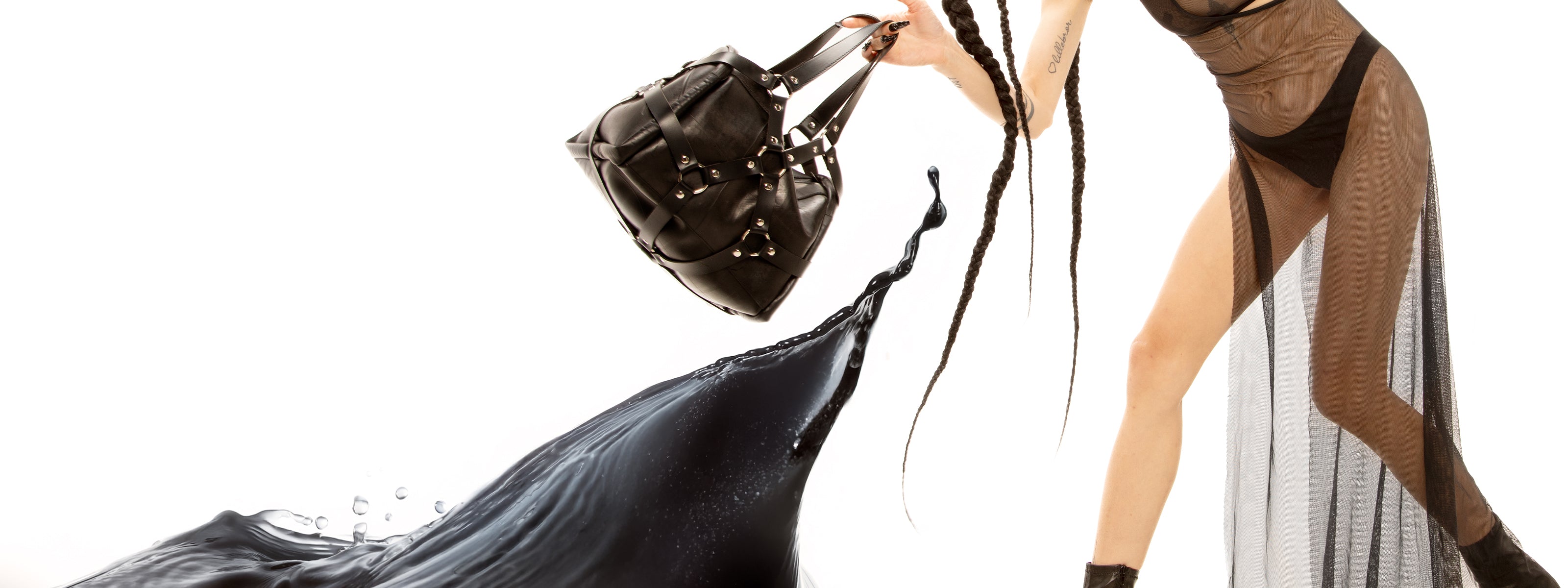 confidently swings a chic, edgy bag crafted from vegan leather while donning a daring black mesh dress. This striking ensemble blends contemporary style with a touch of rebellious flair, creating a look that is both fashion-forward and sustainable.