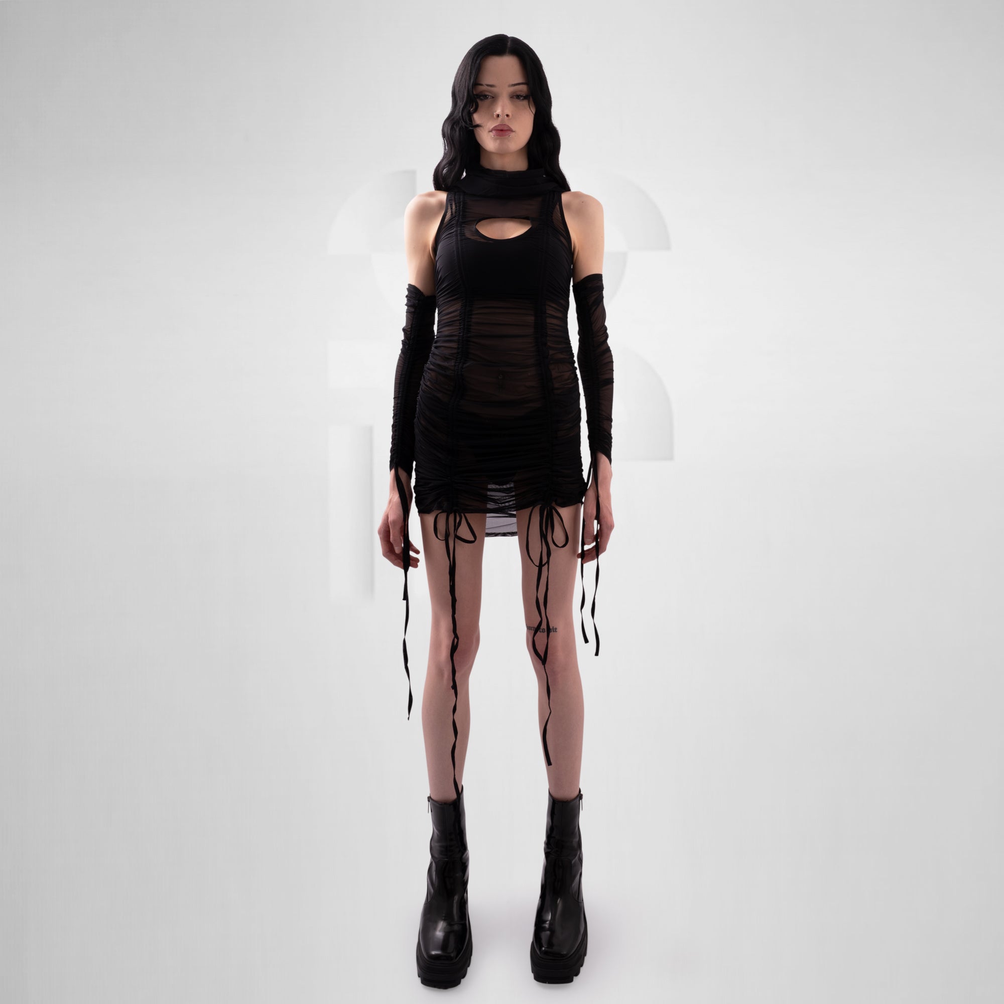 Woman wearing a black outfit with gloves and boots on a white background