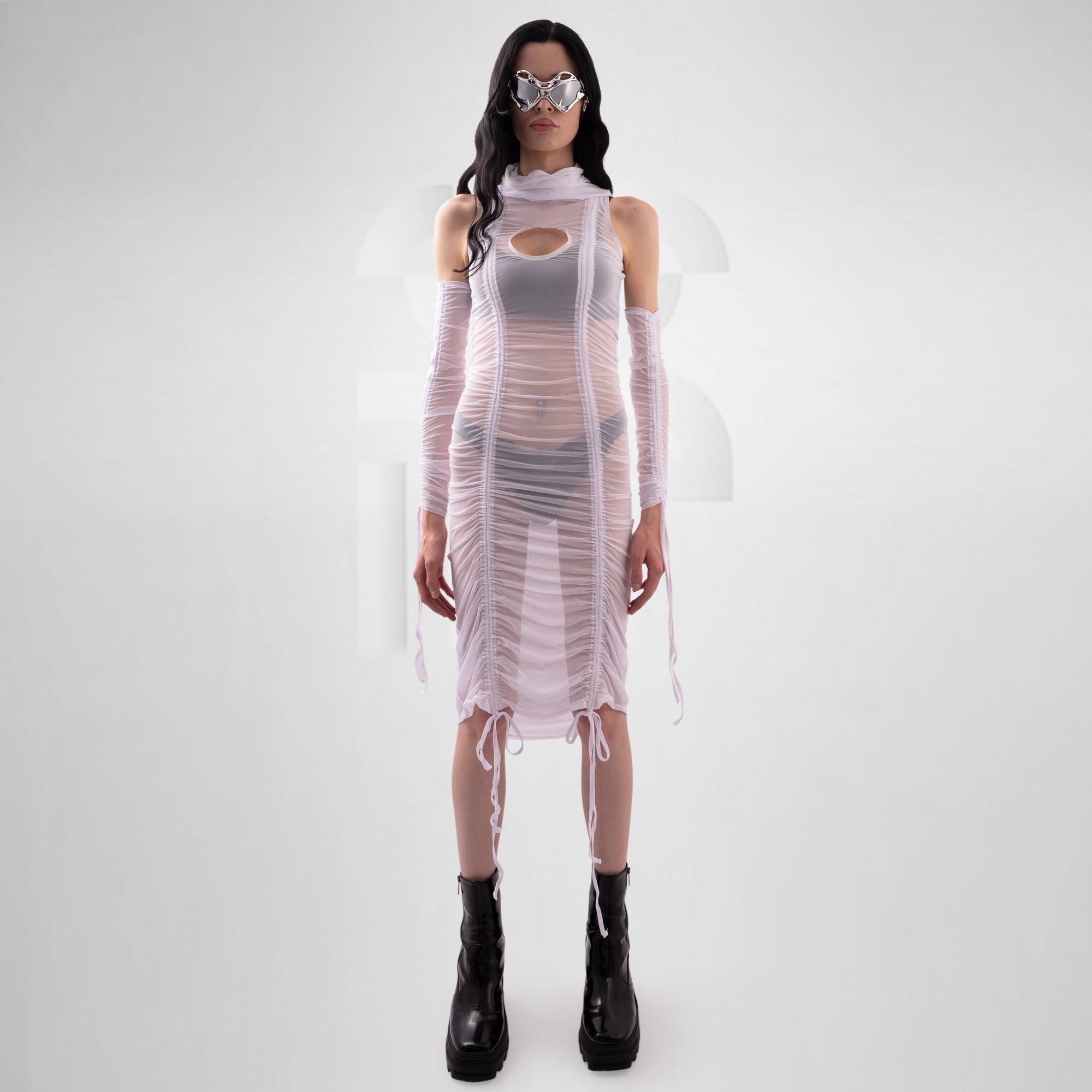 Person wearing a sheer outfit with black boots on a white background