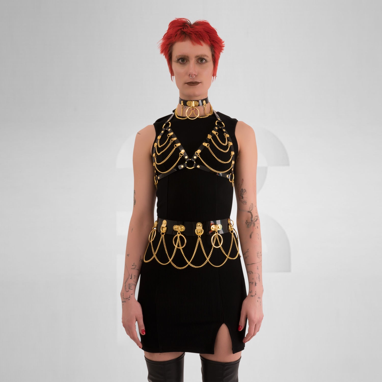 he Kinky Full Body Set in Black PVC from Miss Overdose, featuring a high-gloss finish and silver rings. This harness-style outfit is designed for edgy looks, perfect for kinky parties and club nights, adding a striking touch to any ensemble.