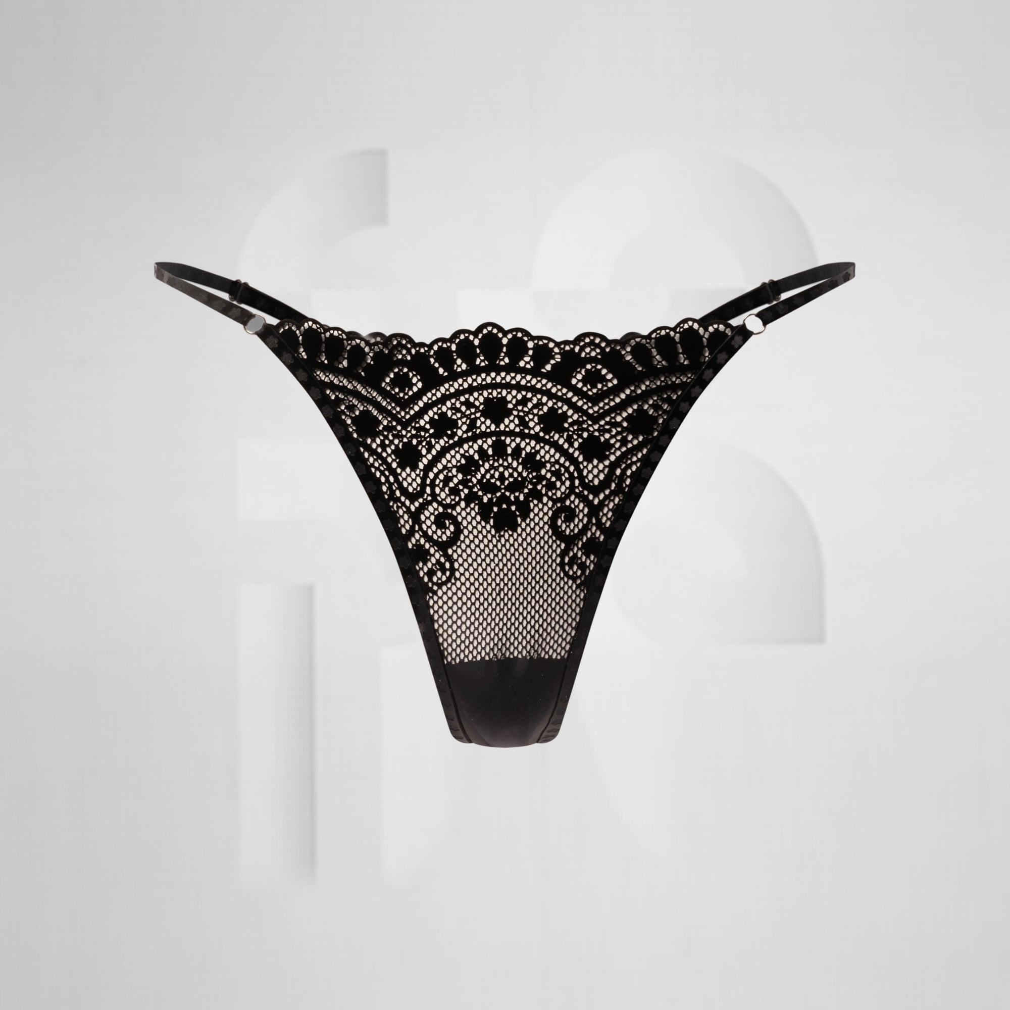 black latex thong with lace effect in front of grey background