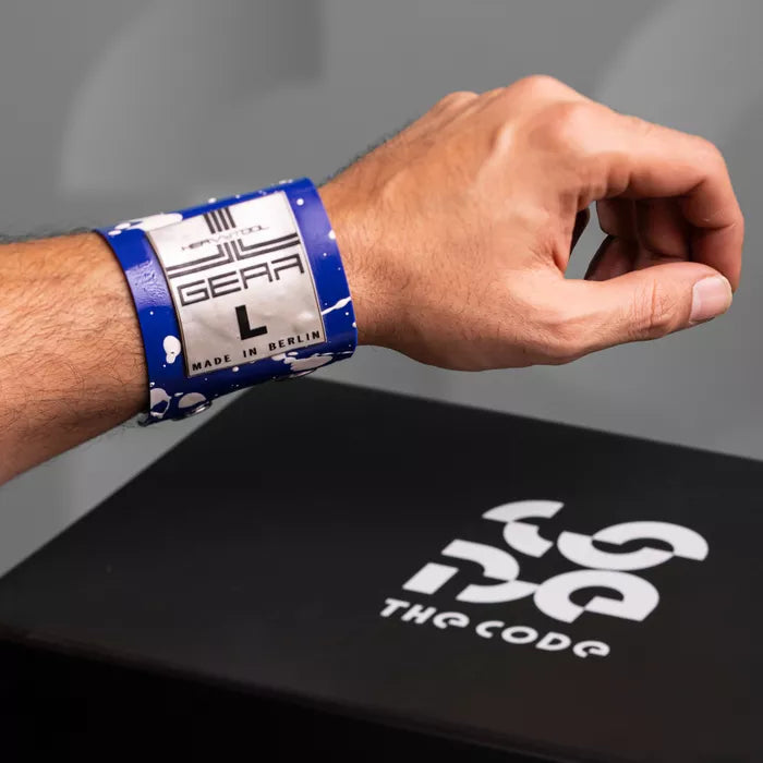 The image showcases a bold Latex Clutch Bracelet Bag, designed for a striking look. This unique accessory wraps around the wrist, combining functionality with edgy style. Featuring a distinctive graphic design, it embodies the essence of avant-garde fashion, making it a perfect statement piece for any occasion.