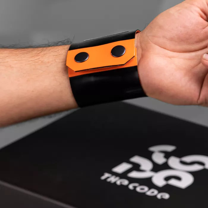 The image showcases a bold Latex Clutch Bracelet Bag, designed for a striking look. This unique accessory wraps around the wrist, combining functionality with edgy style. Featuring a distinctive graphic design, it embodies the essence of avant-garde fashion, making it a perfect statement piece for any occasion.