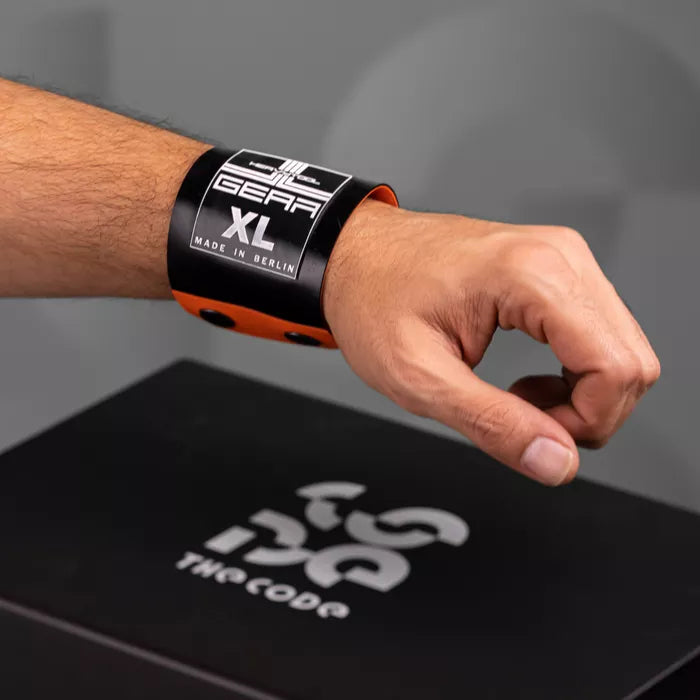 The image showcases a bold Latex Clutch Bracelet Bag, designed for a striking look. This unique accessory wraps around the wrist, combining functionality with edgy style. Featuring a distinctive graphic design, it embodies the essence of avant-garde fashion, making it a perfect statement piece for any occasion.